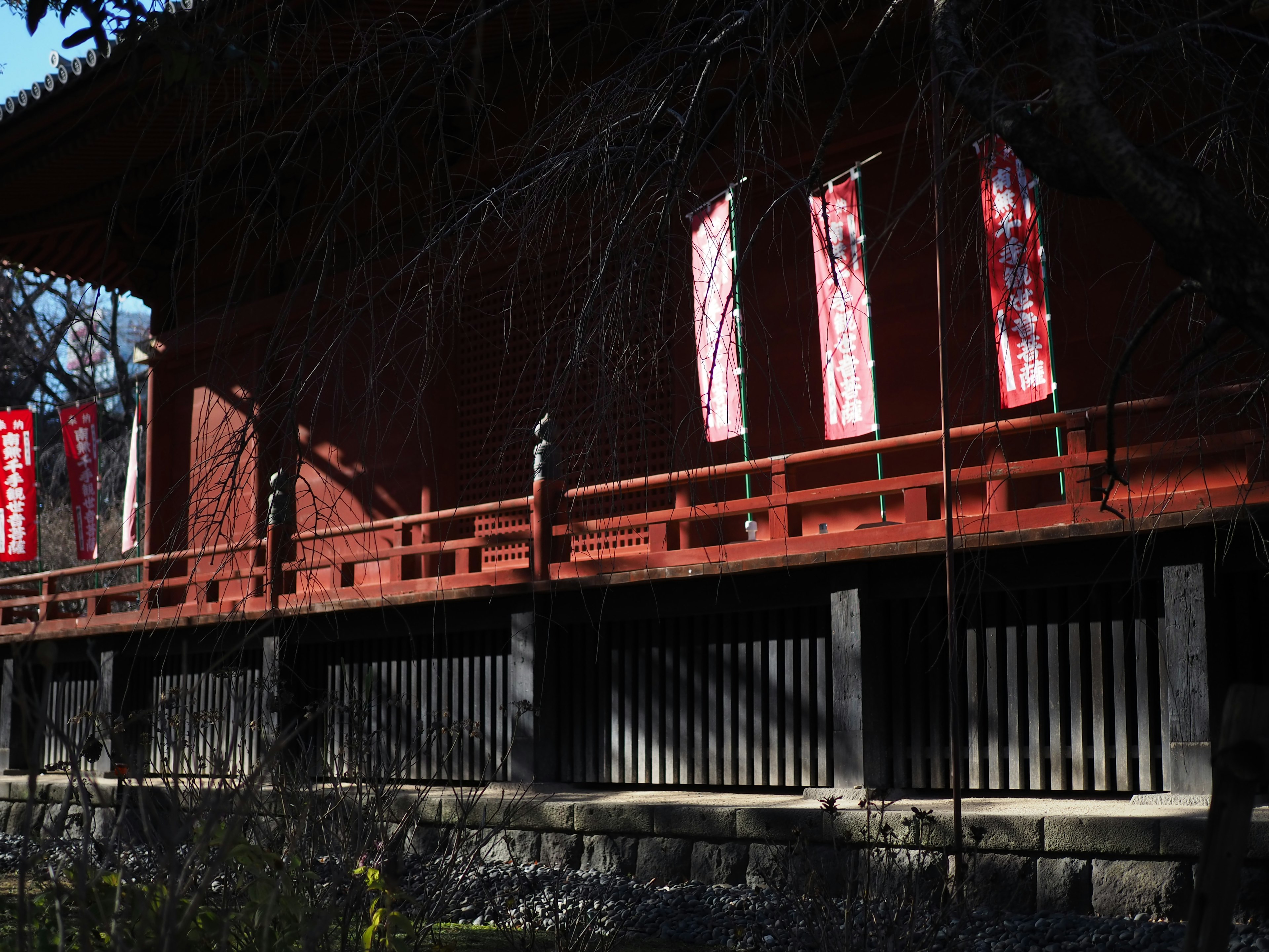 Side view of a traditional building with a red railing and white banners