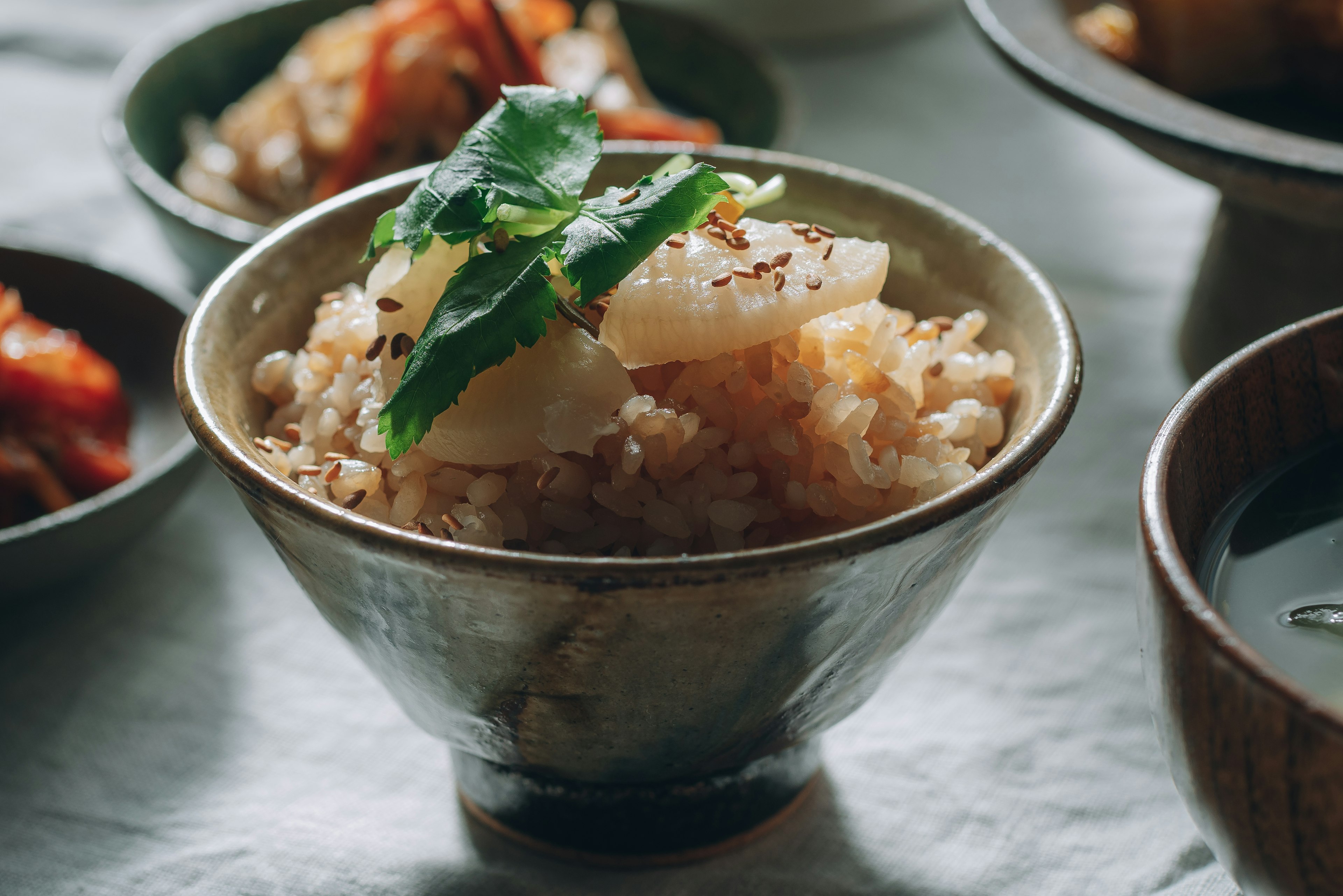 A bowl of rice topped with fresh herbs and vegetables