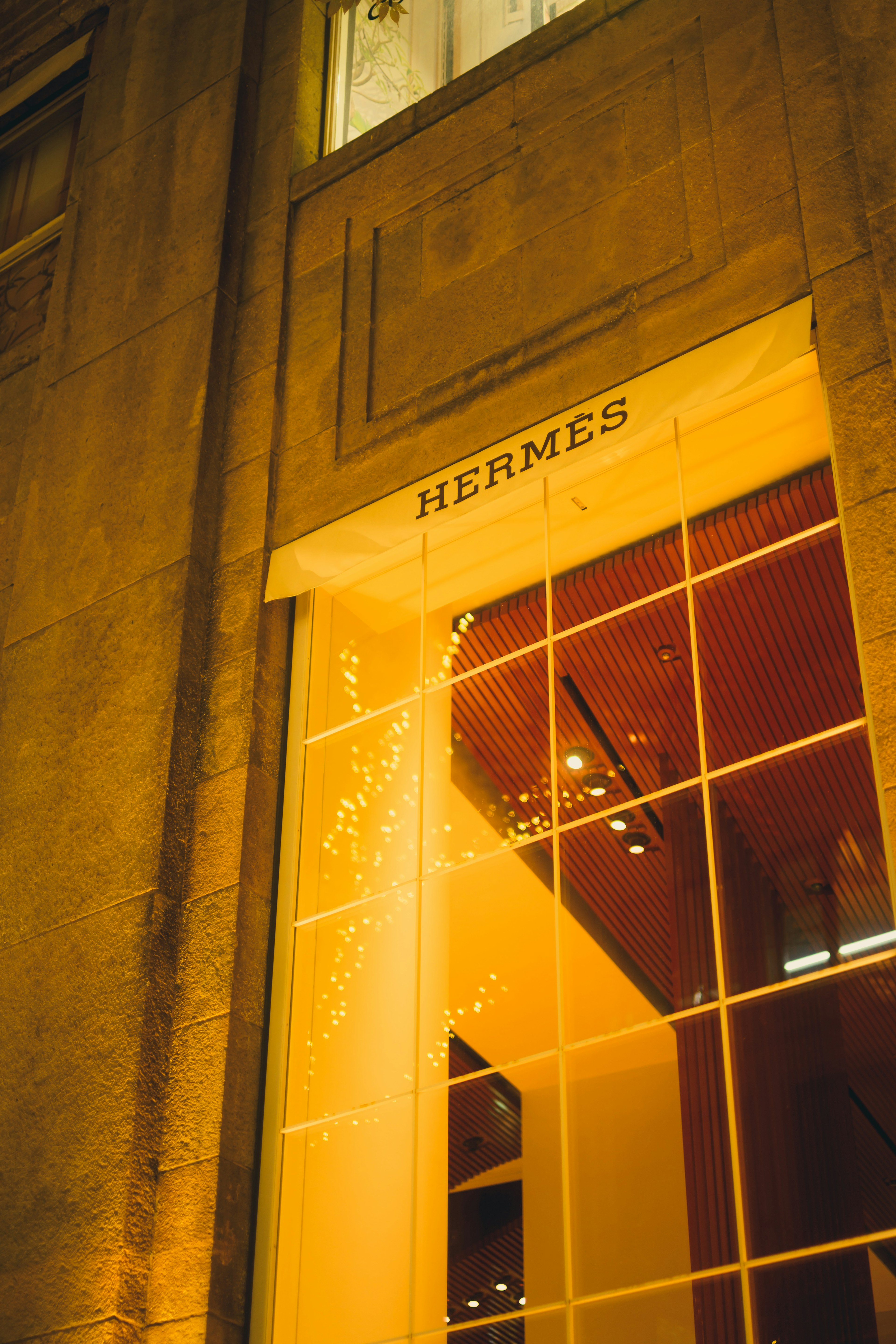 Exterior de la tienda Hermès iluminada por la noche