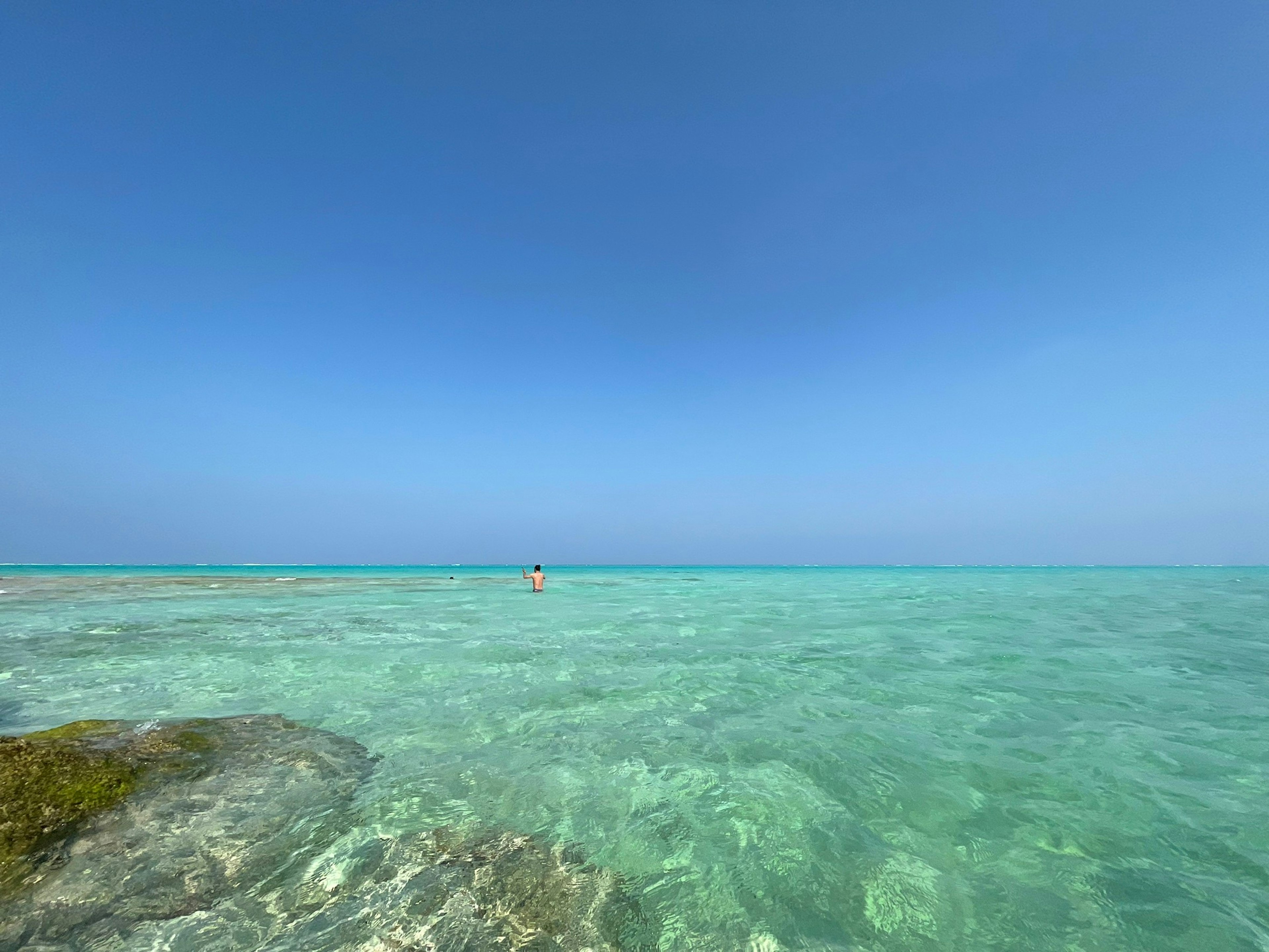 Pemandangan pantai yang indah dengan air jernih dan langit biru