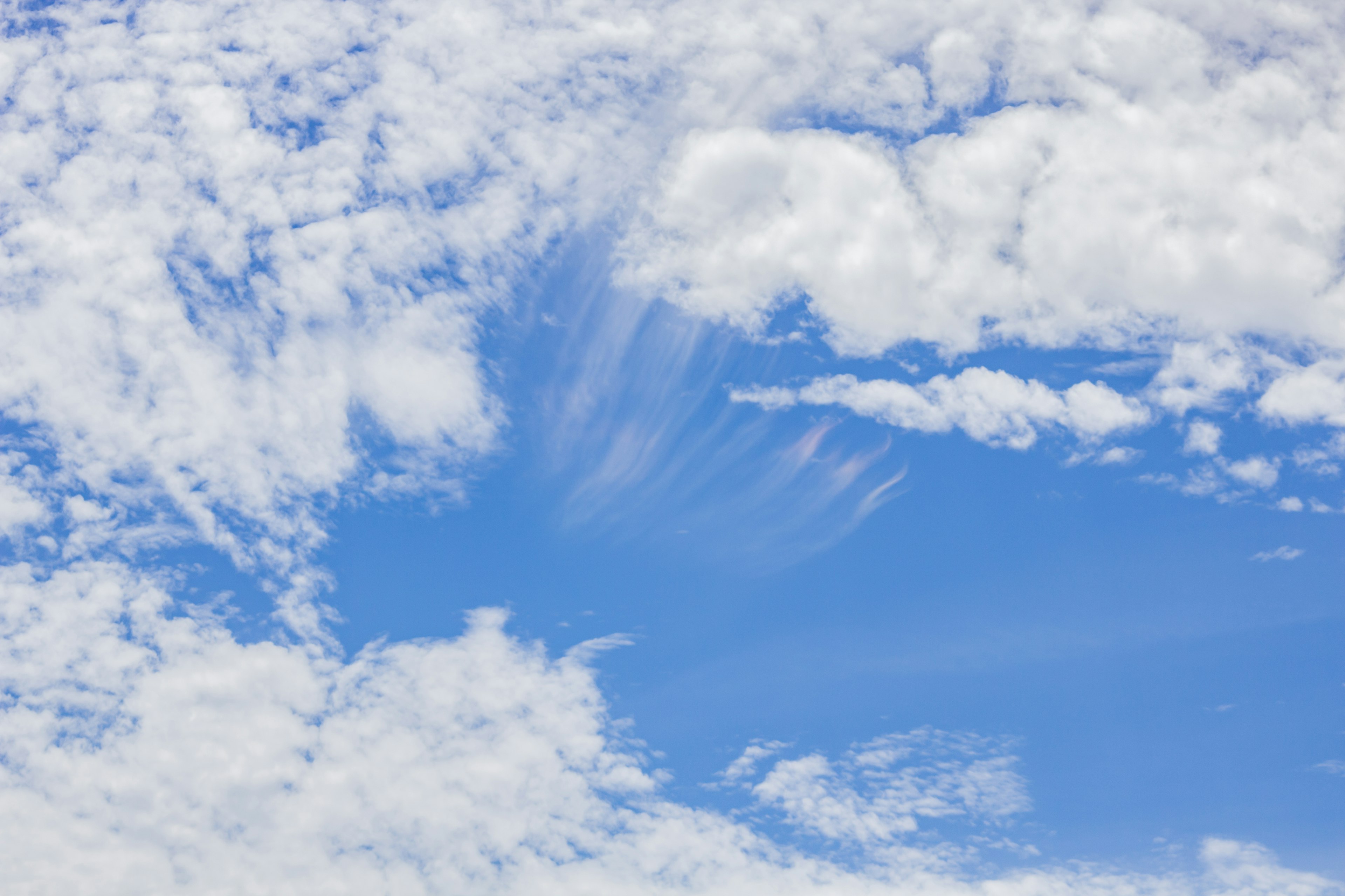 Eine Landschaft mit blauem Himmel und weißen Wolken