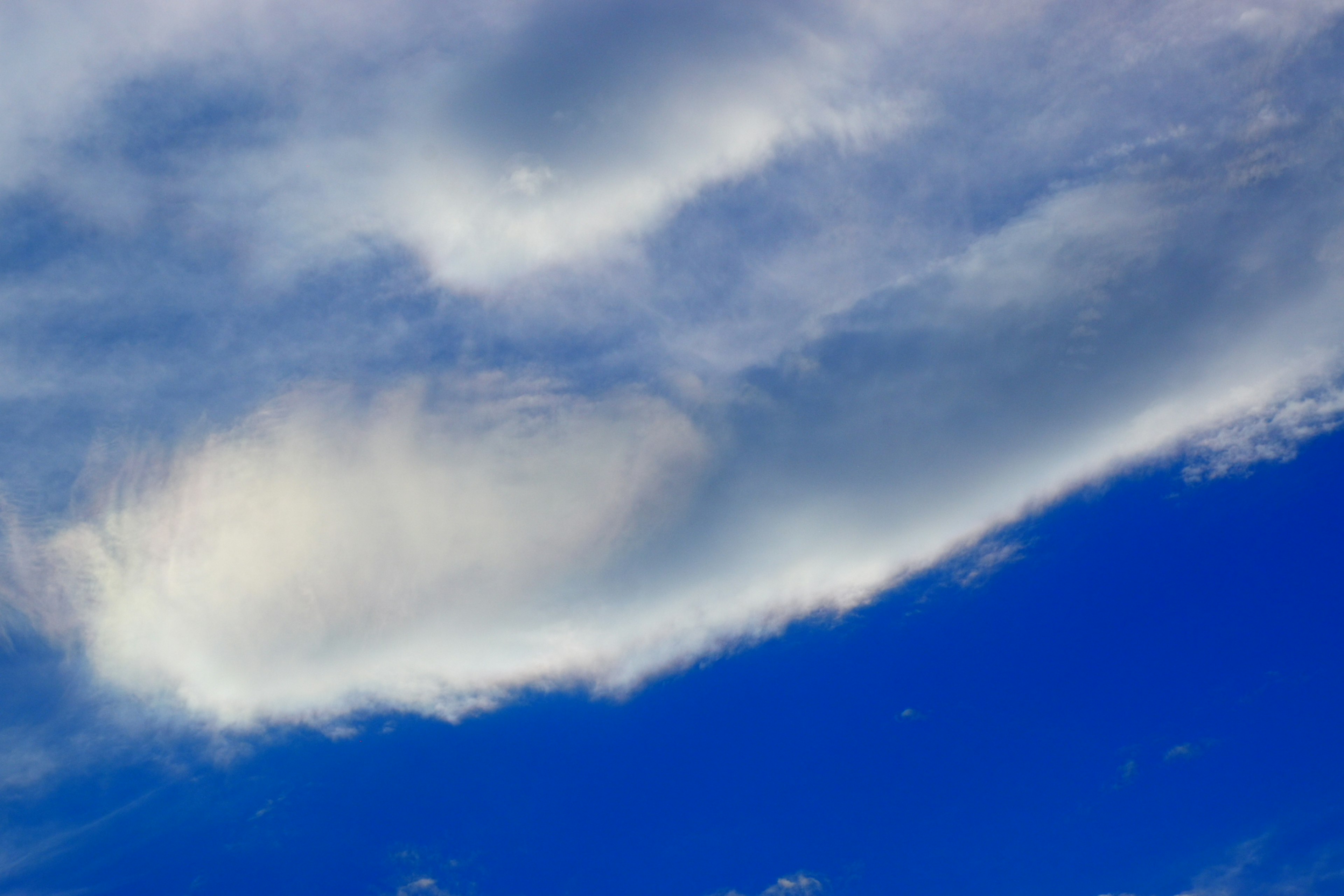 Einzigartig geformte weiße Wolken in einem blauen Himmel