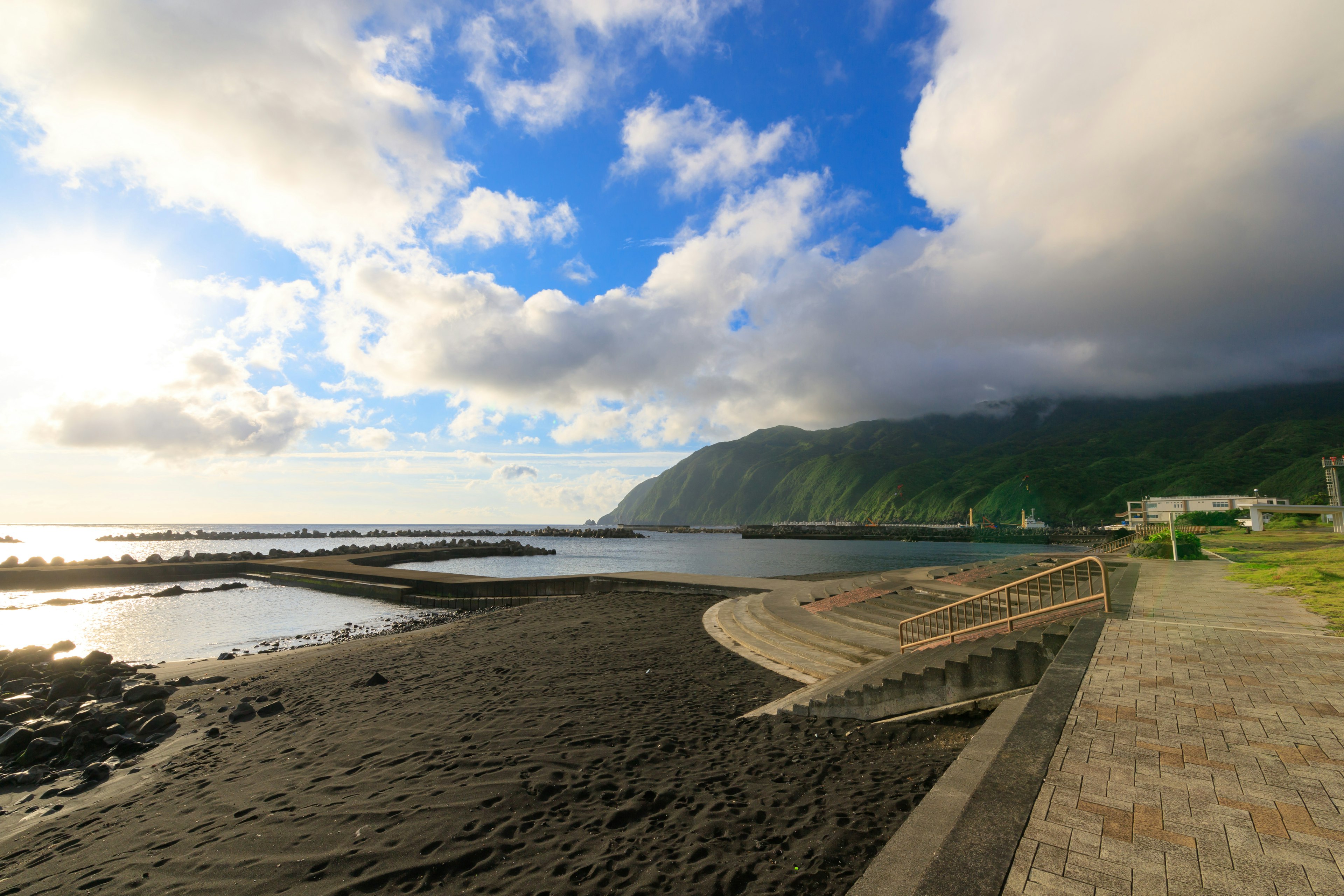 Panoramablick auf eine Küste mit Bergen und bewölktem Himmel