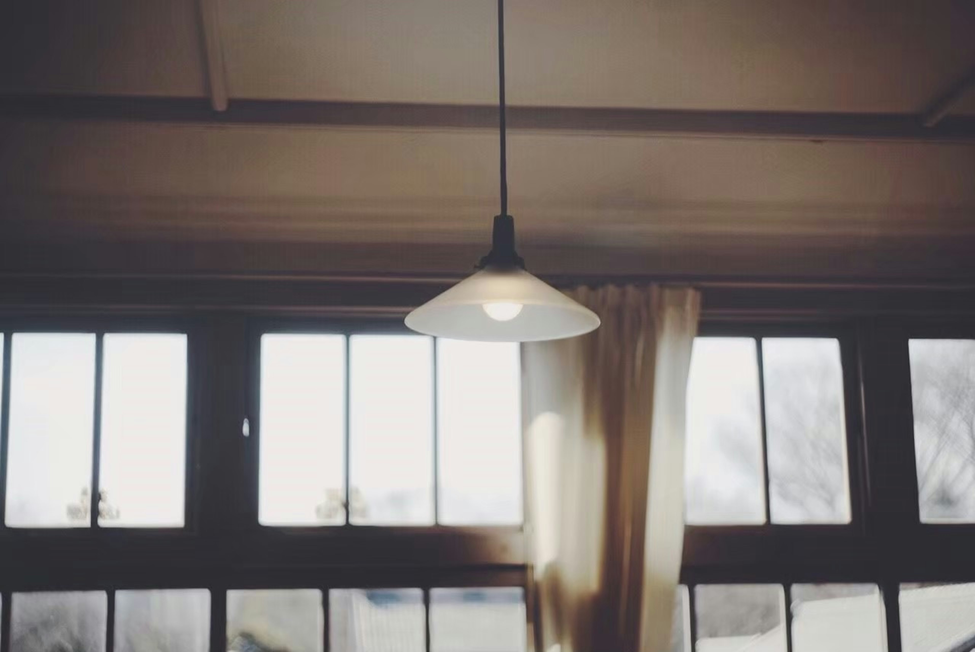 Pendant lamp in a room with windows and curtains