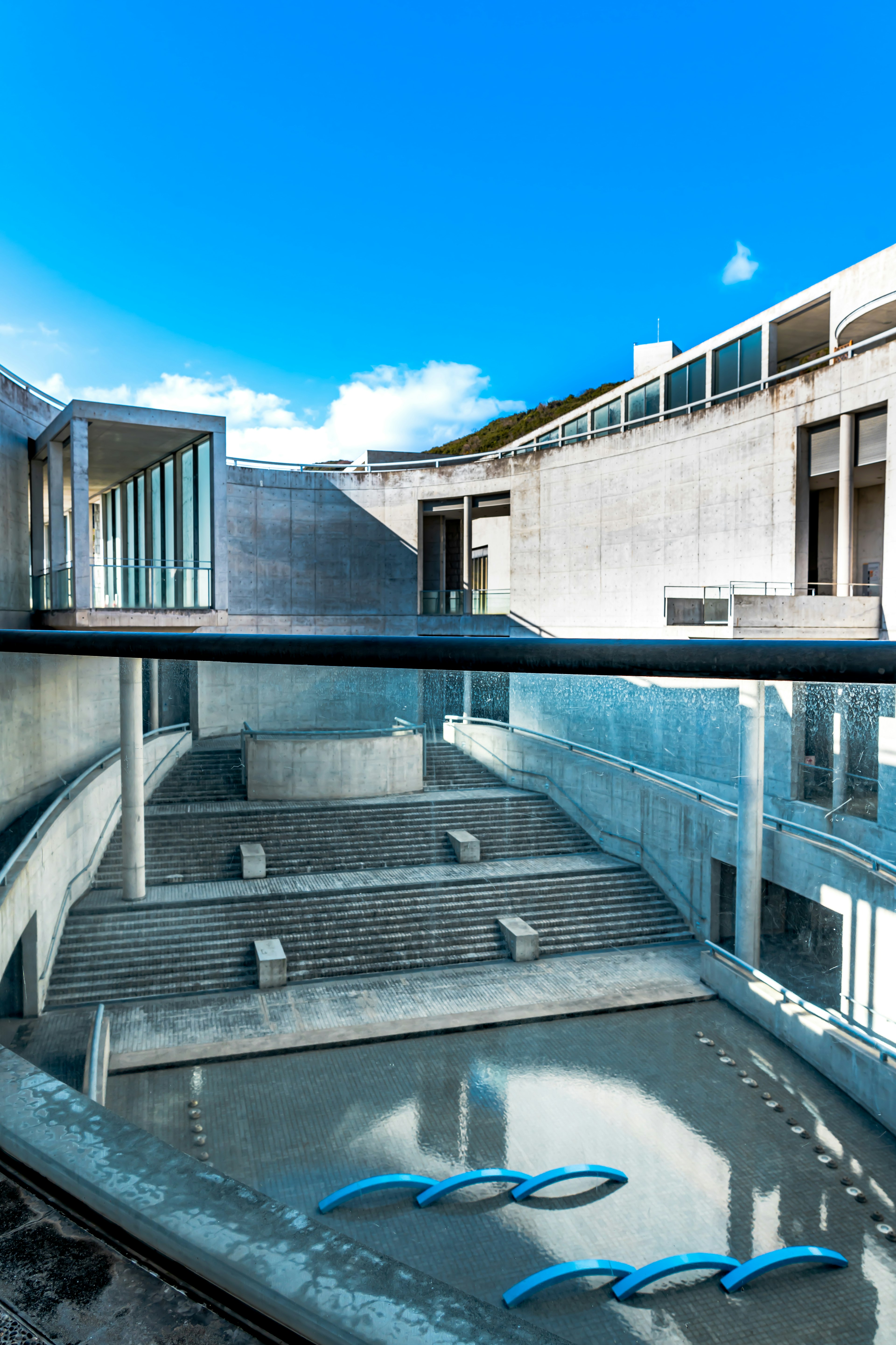 Foto de un patio arquitectónico moderno con agua que refleja el cielo azul