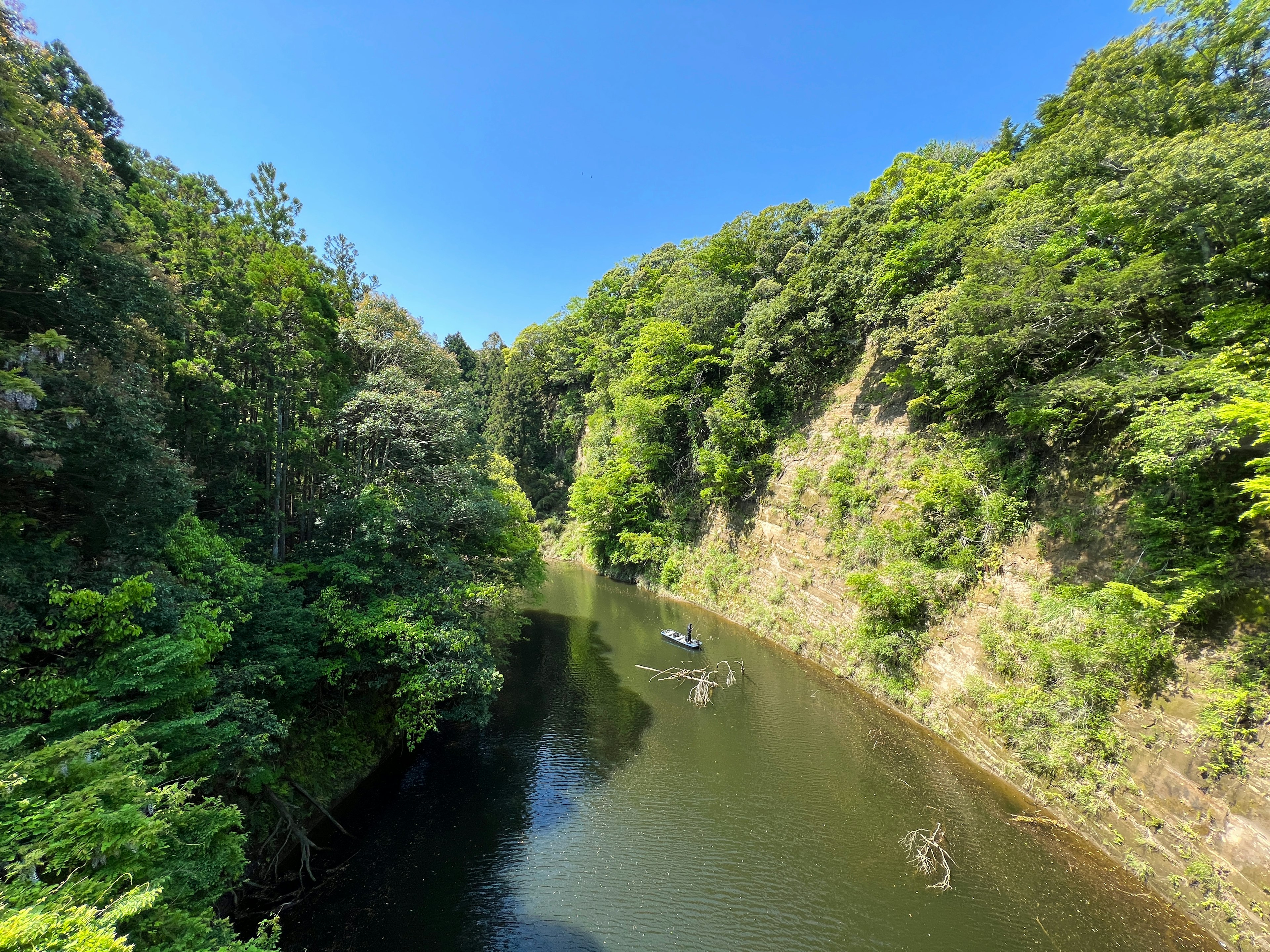 Lush green valley and tranquil river under a clear blue sky