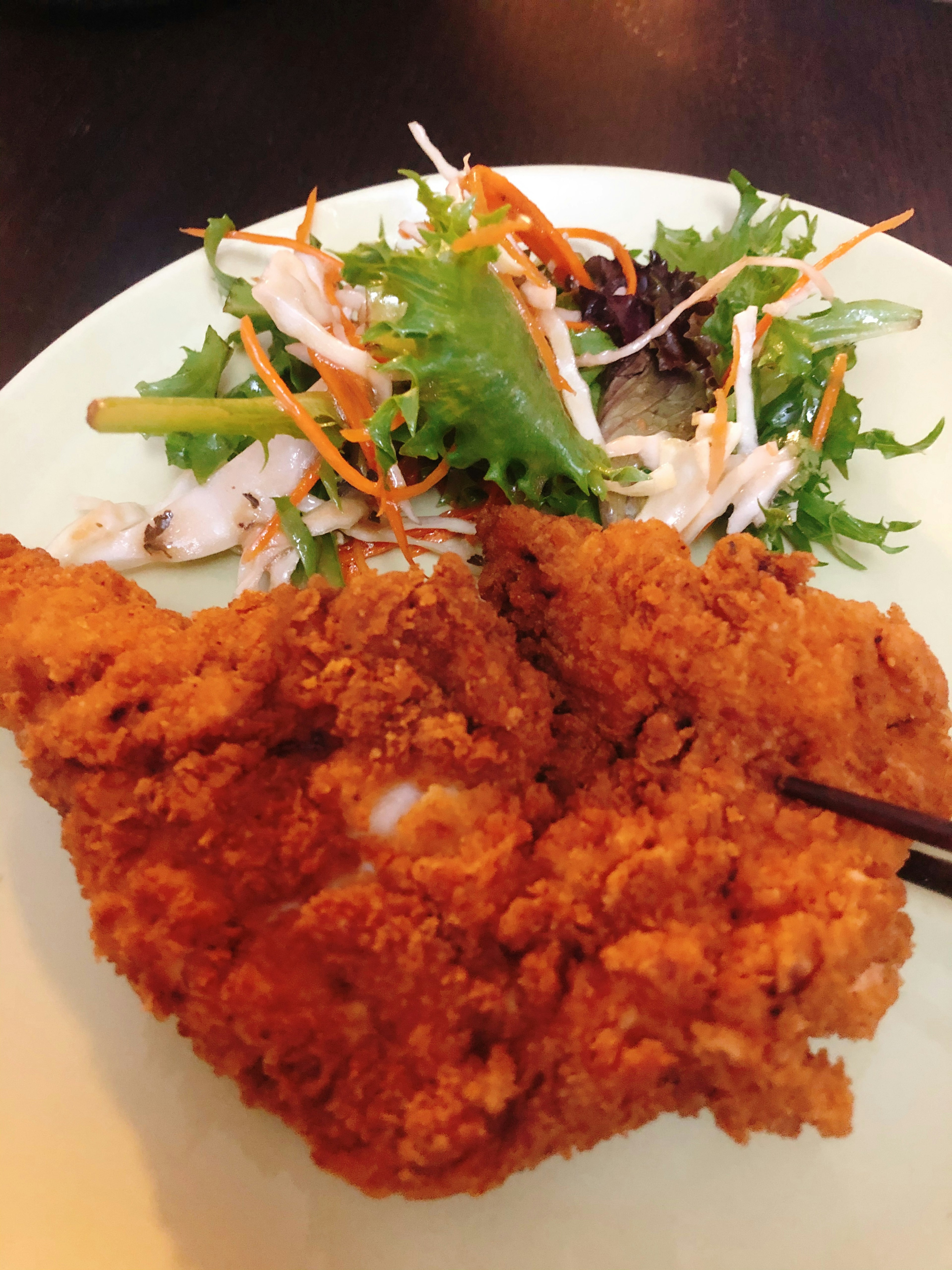 Un plato con pollo frito crujiente junto a una ensalada fresca