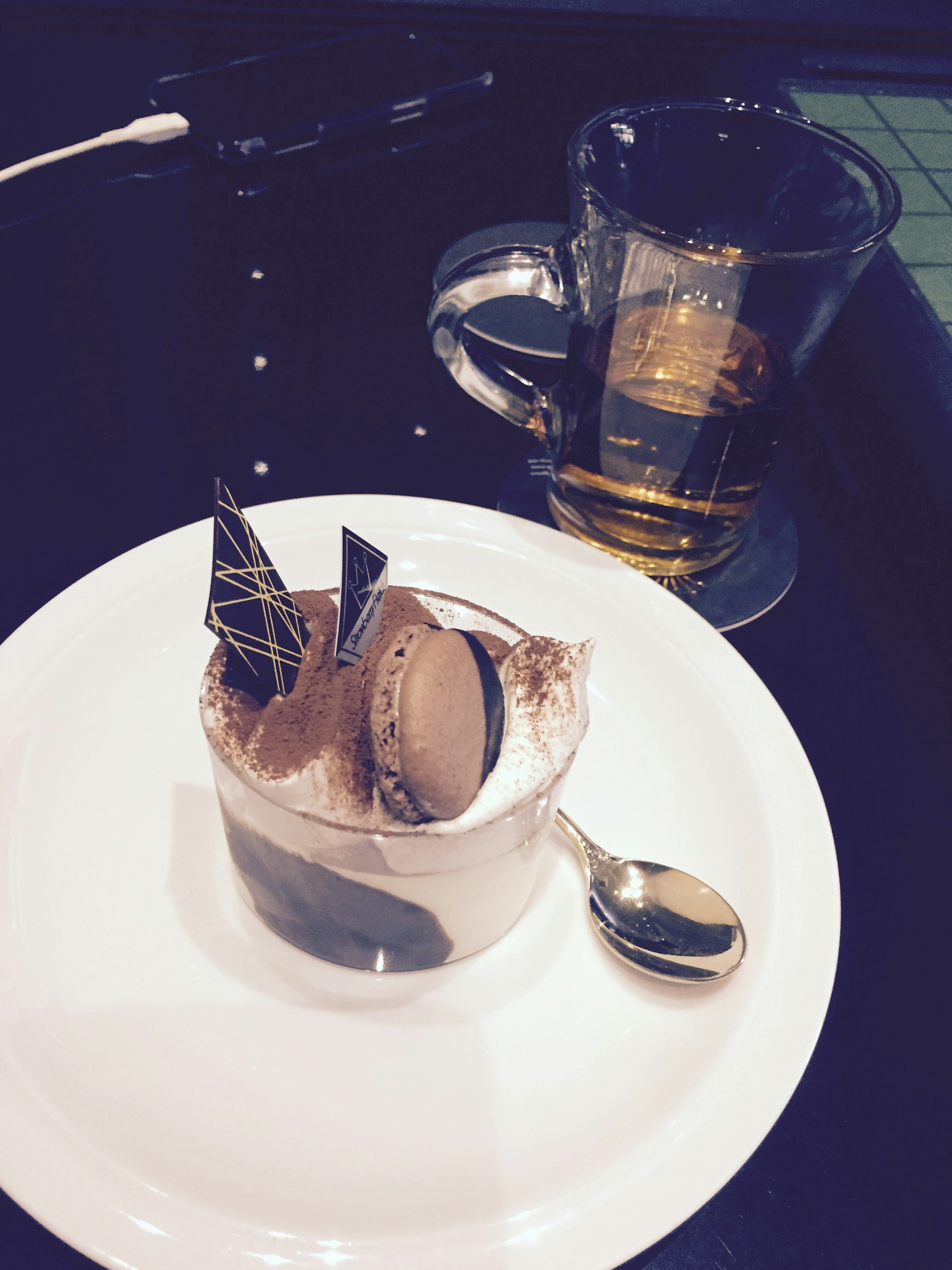 Chocolate dessert with decorative elements and a glass of drink