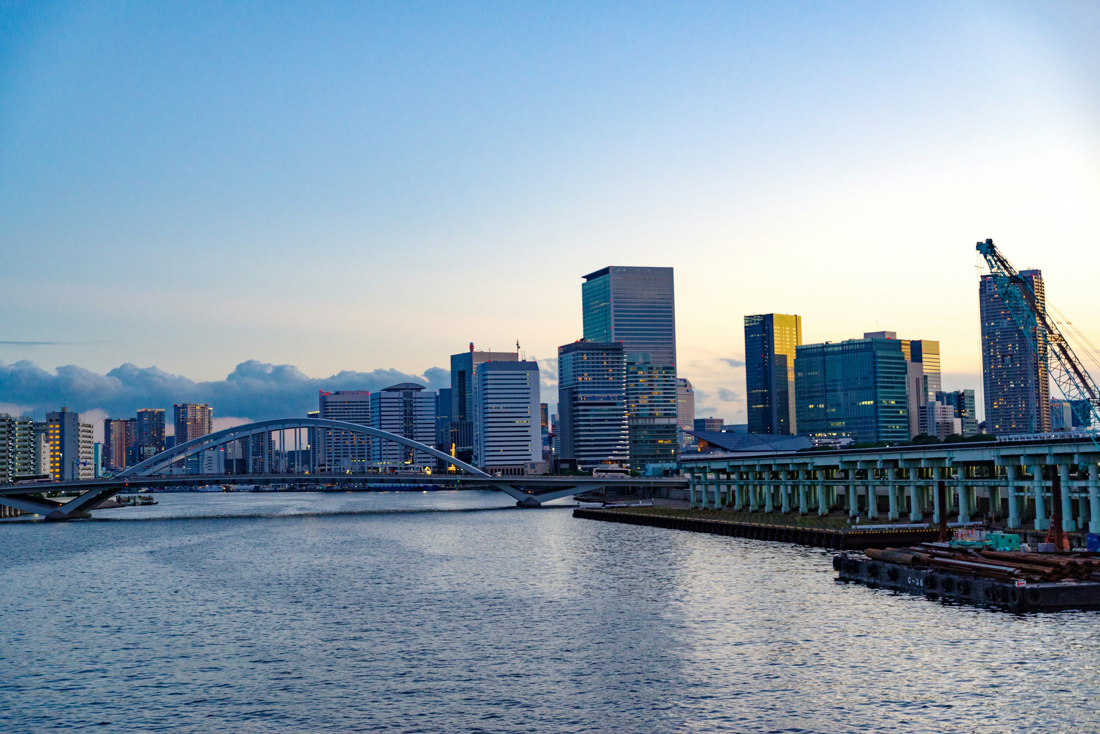 Skyline della città al crepuscolo con un fiume in primo piano