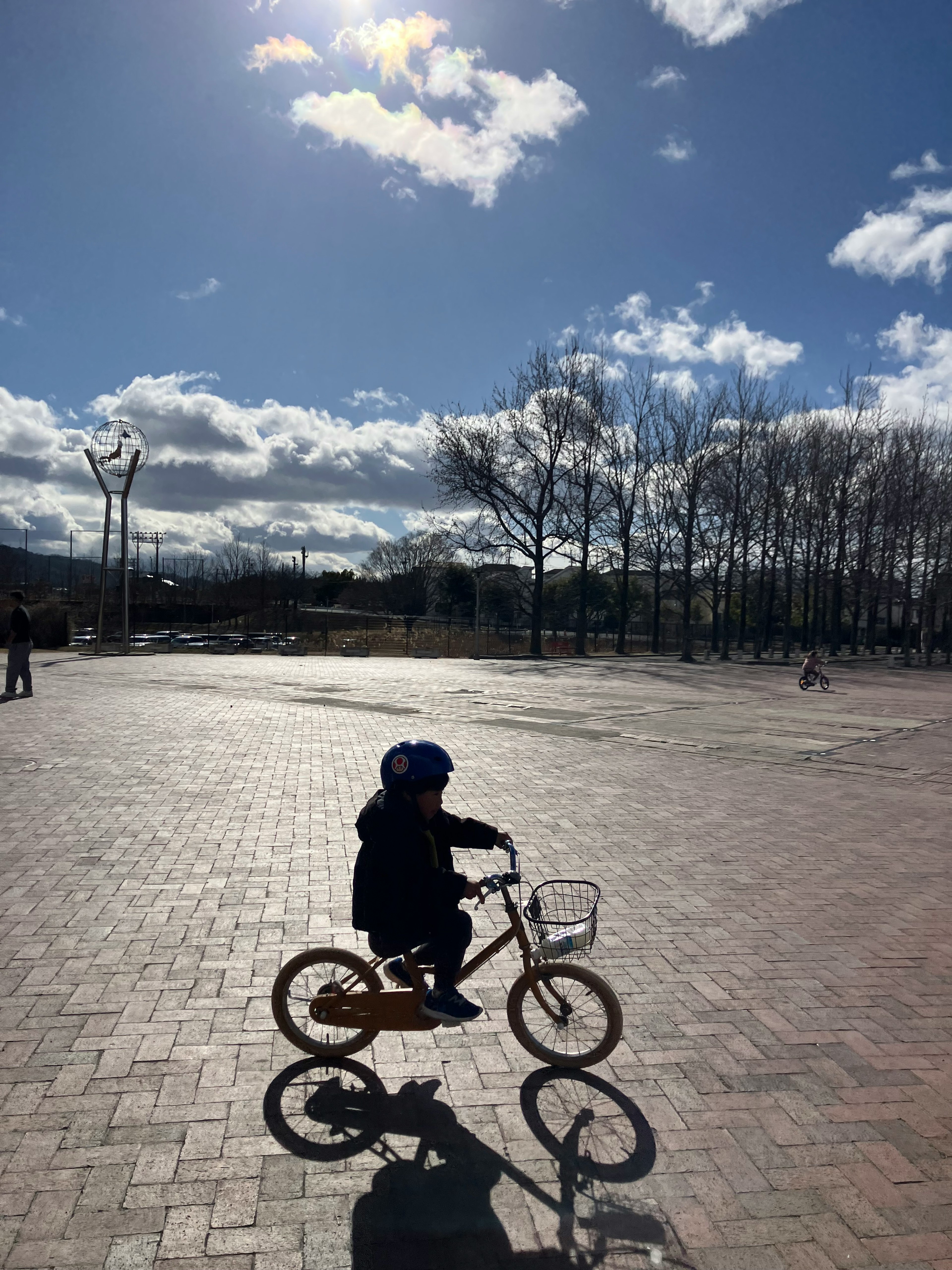 青いヘルメットをかぶった子供が自転車に乗っている晴れた日