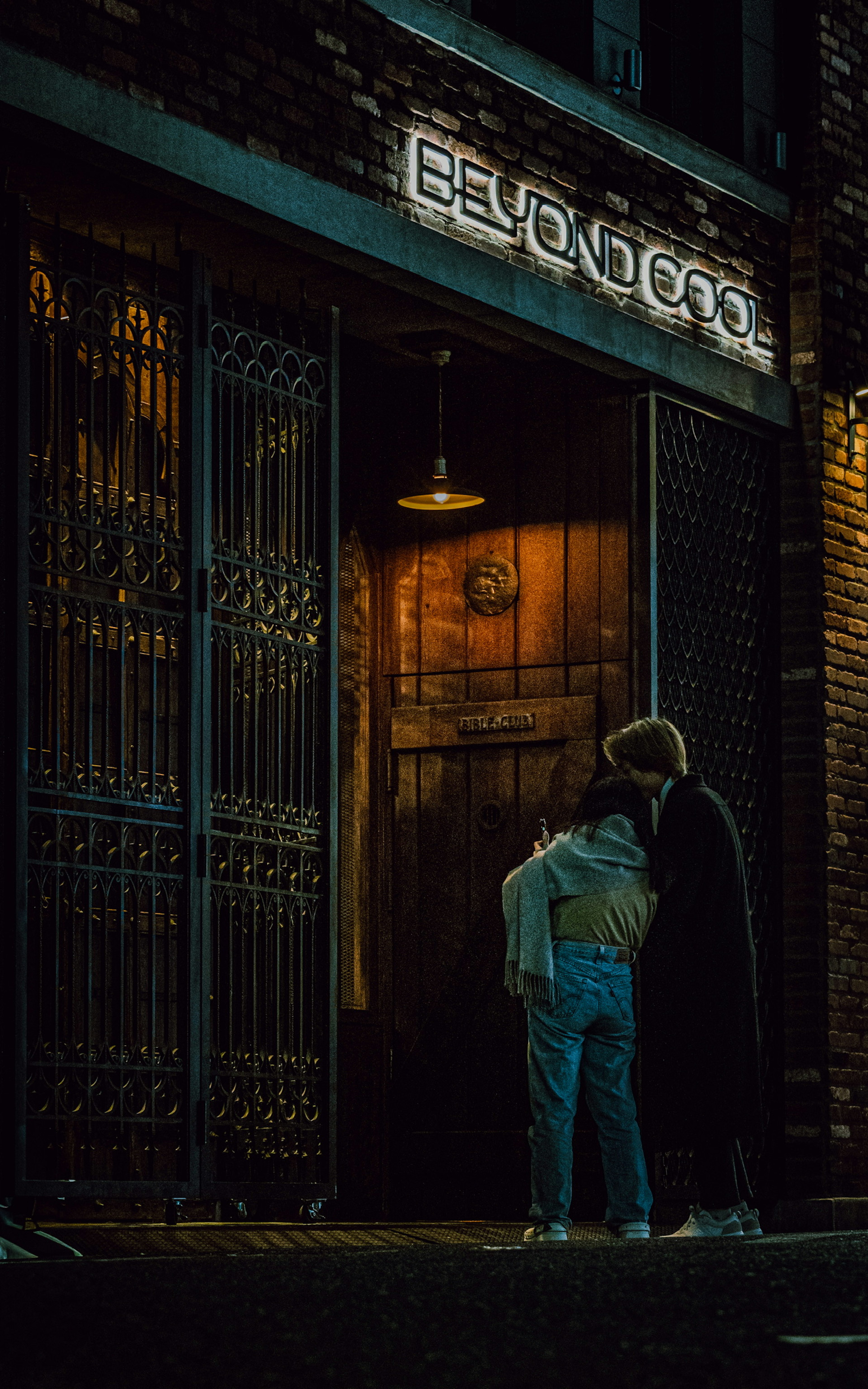 Due persone davanti a un ingresso dell'ascensore in una strada poco illuminata