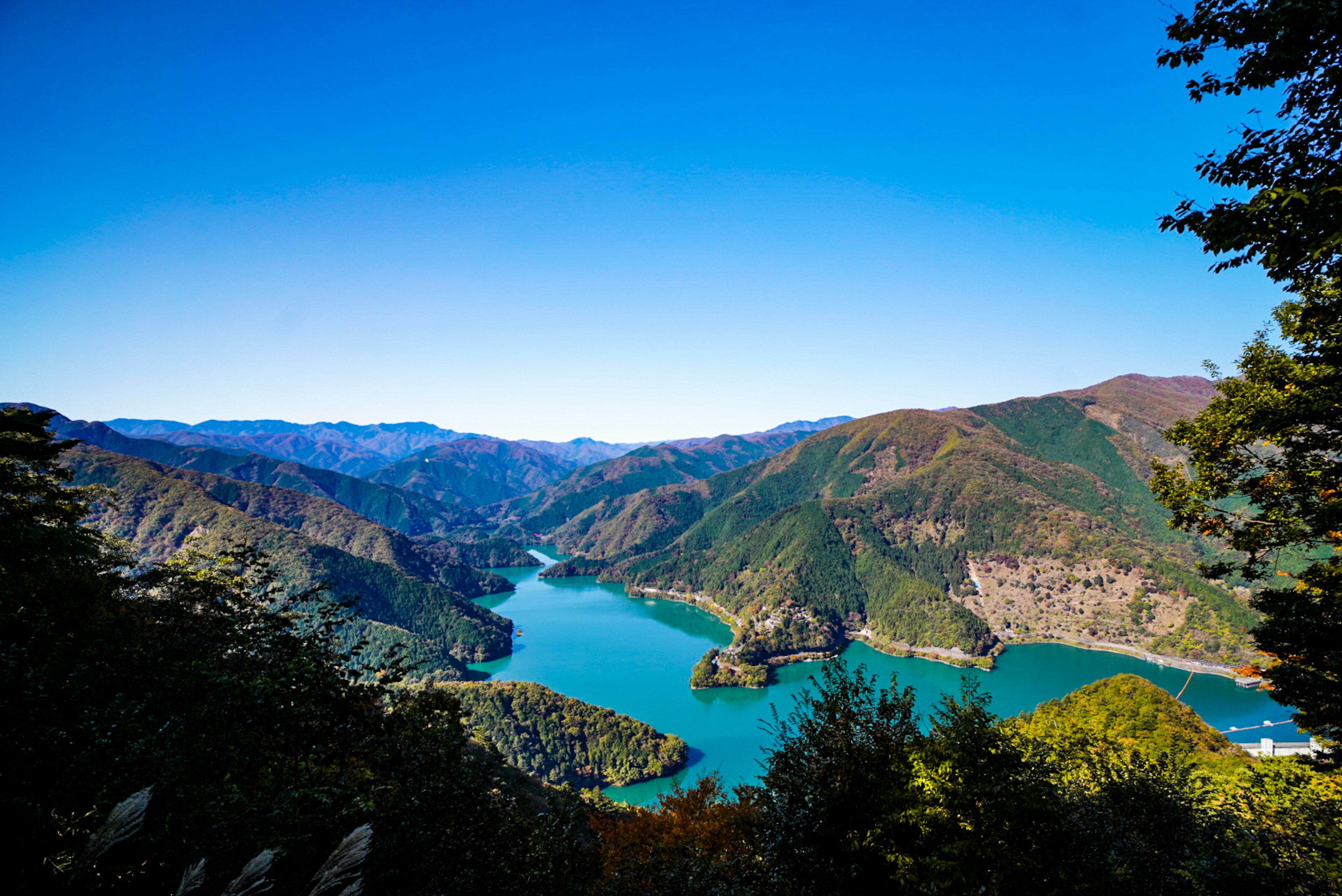 Lago escénico rodeado de montañas bajo un cielo azul claro