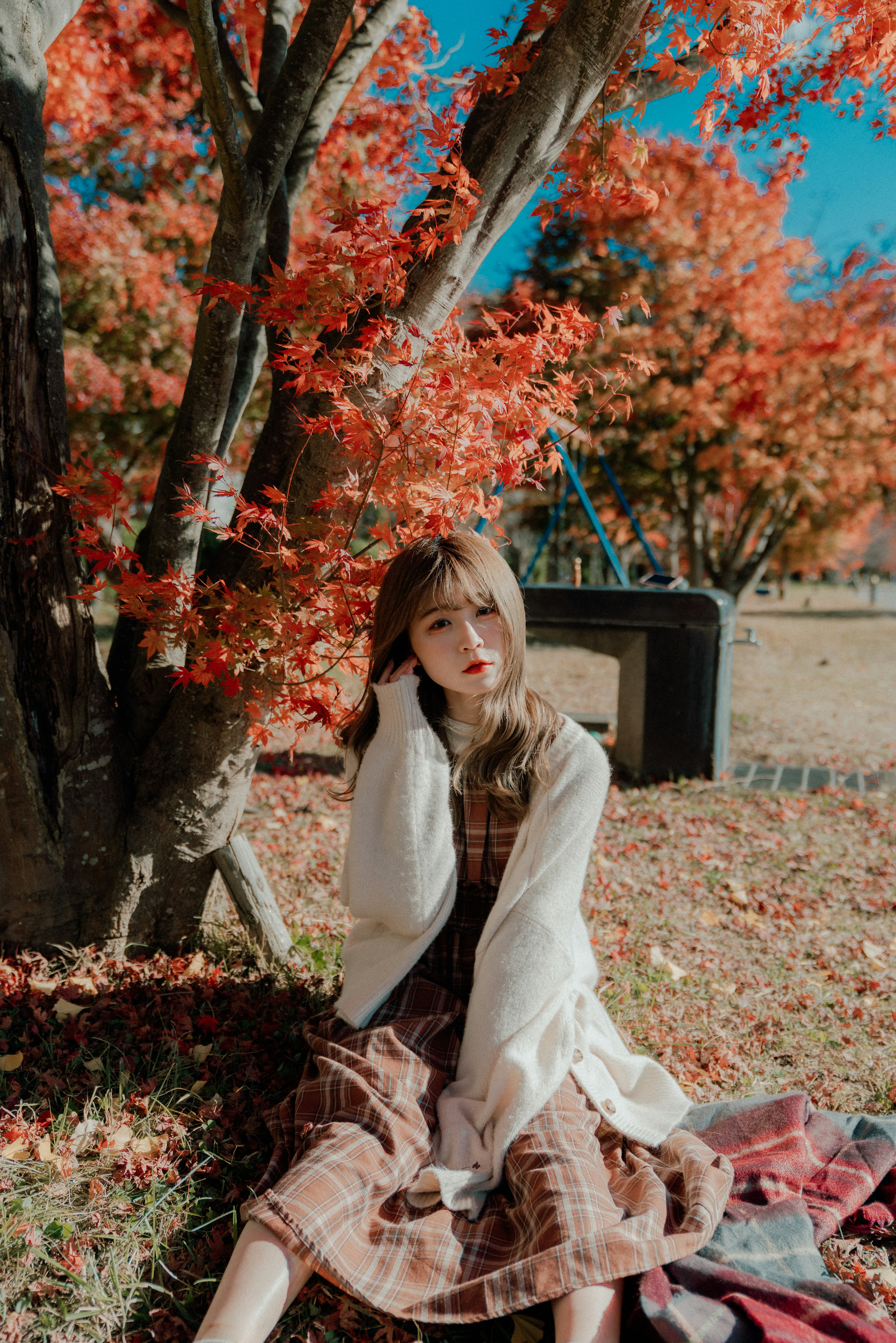 Una mujer posando entre hojas de otoño vibrantes