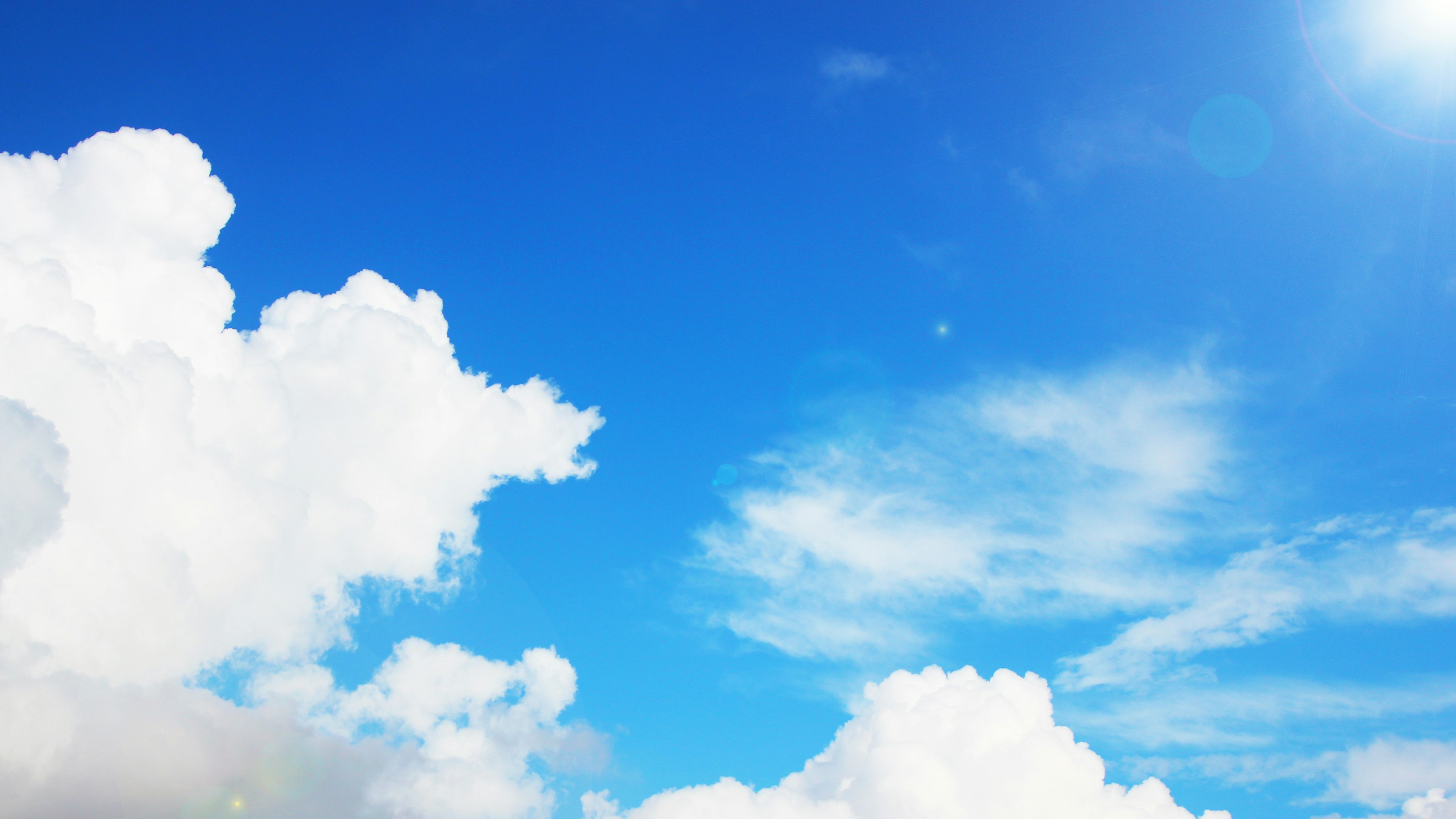 Ciel bleu lumineux avec des nuages blancs duveteux