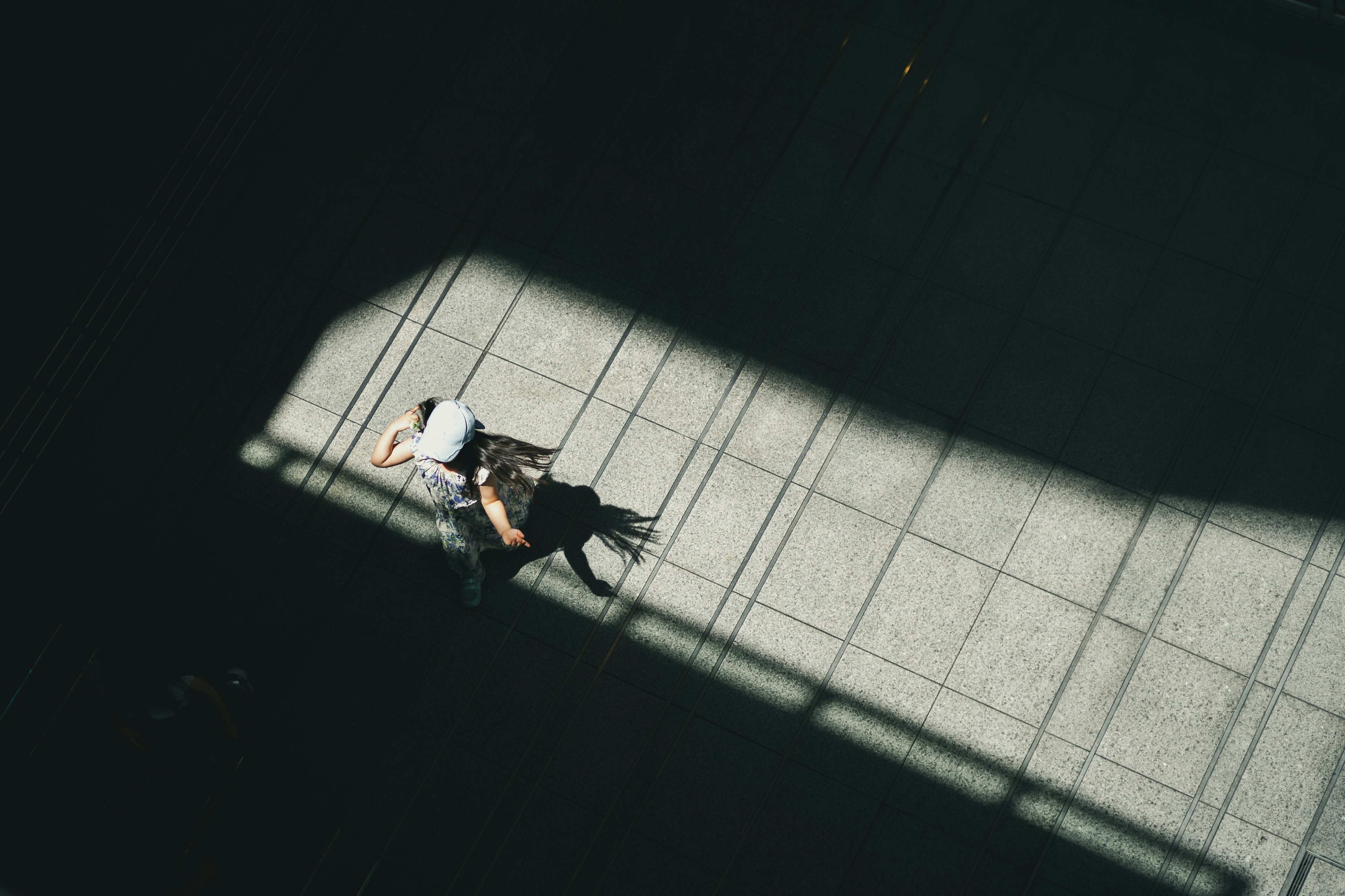 Eine Person liegt im Schatten mit einem langen Schatten auf dem Boden