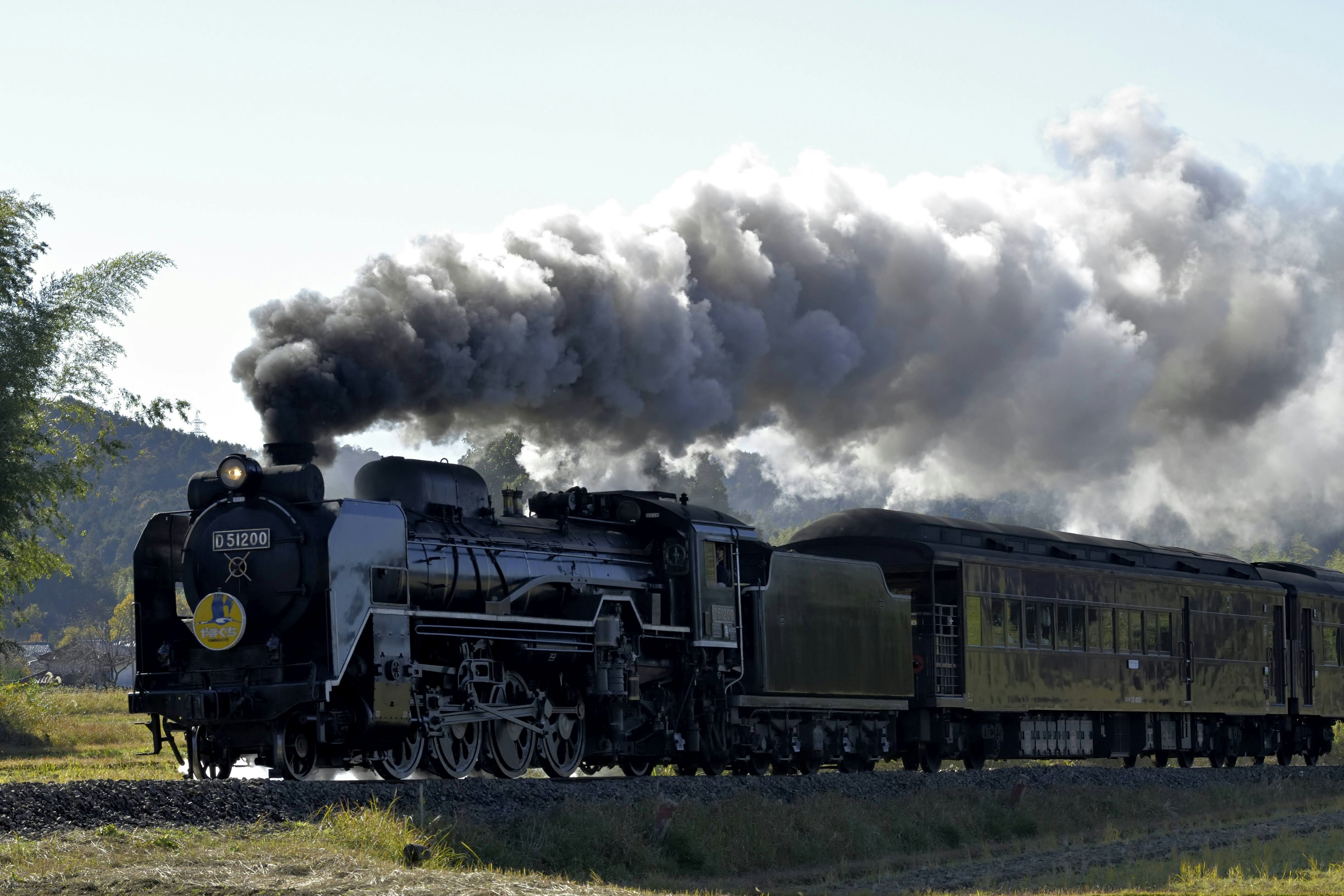 Una locomotora de vapor emitiendo humo mientras viaja