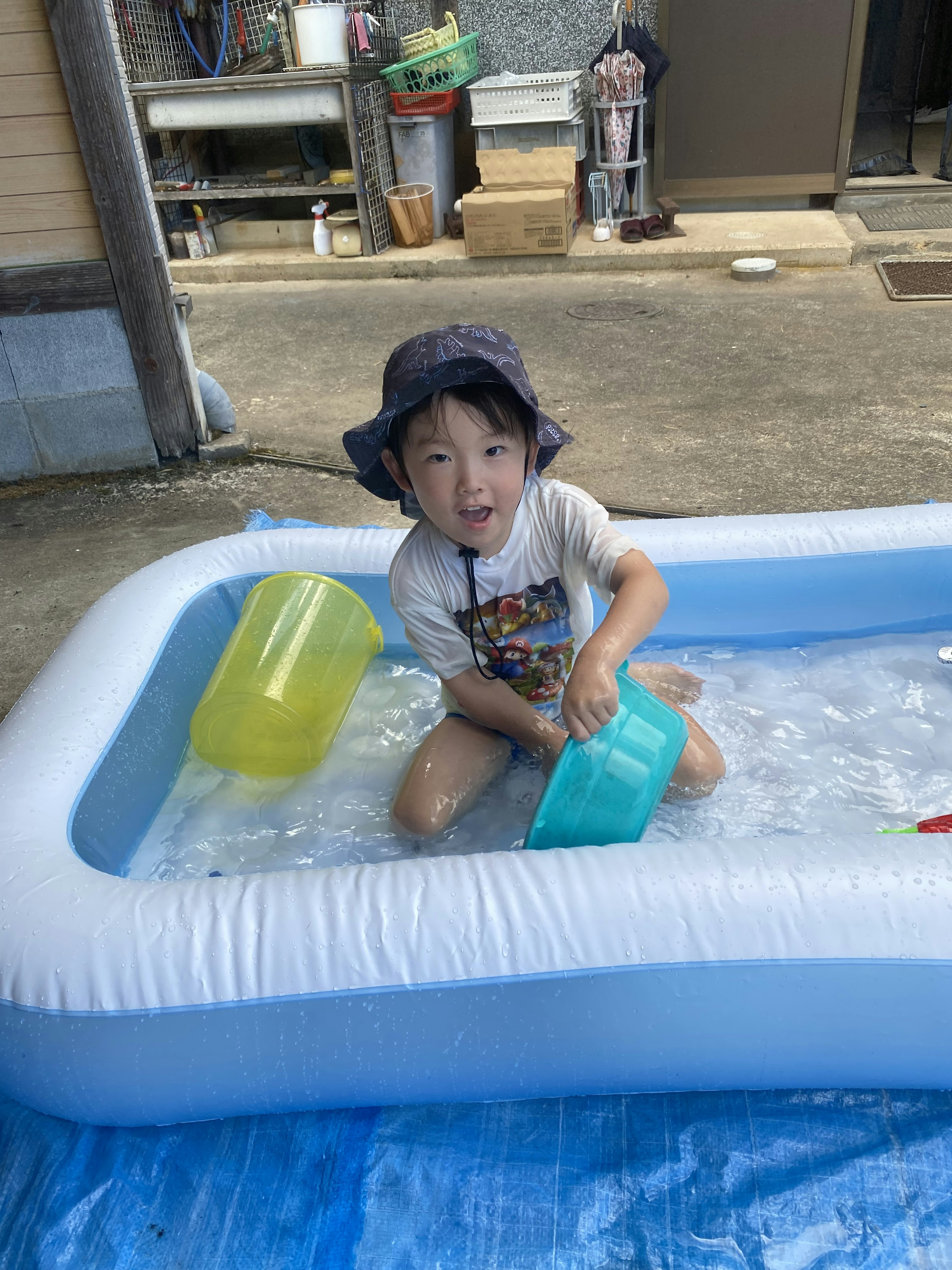 Bambino che gioca in una piscina gonfiabile