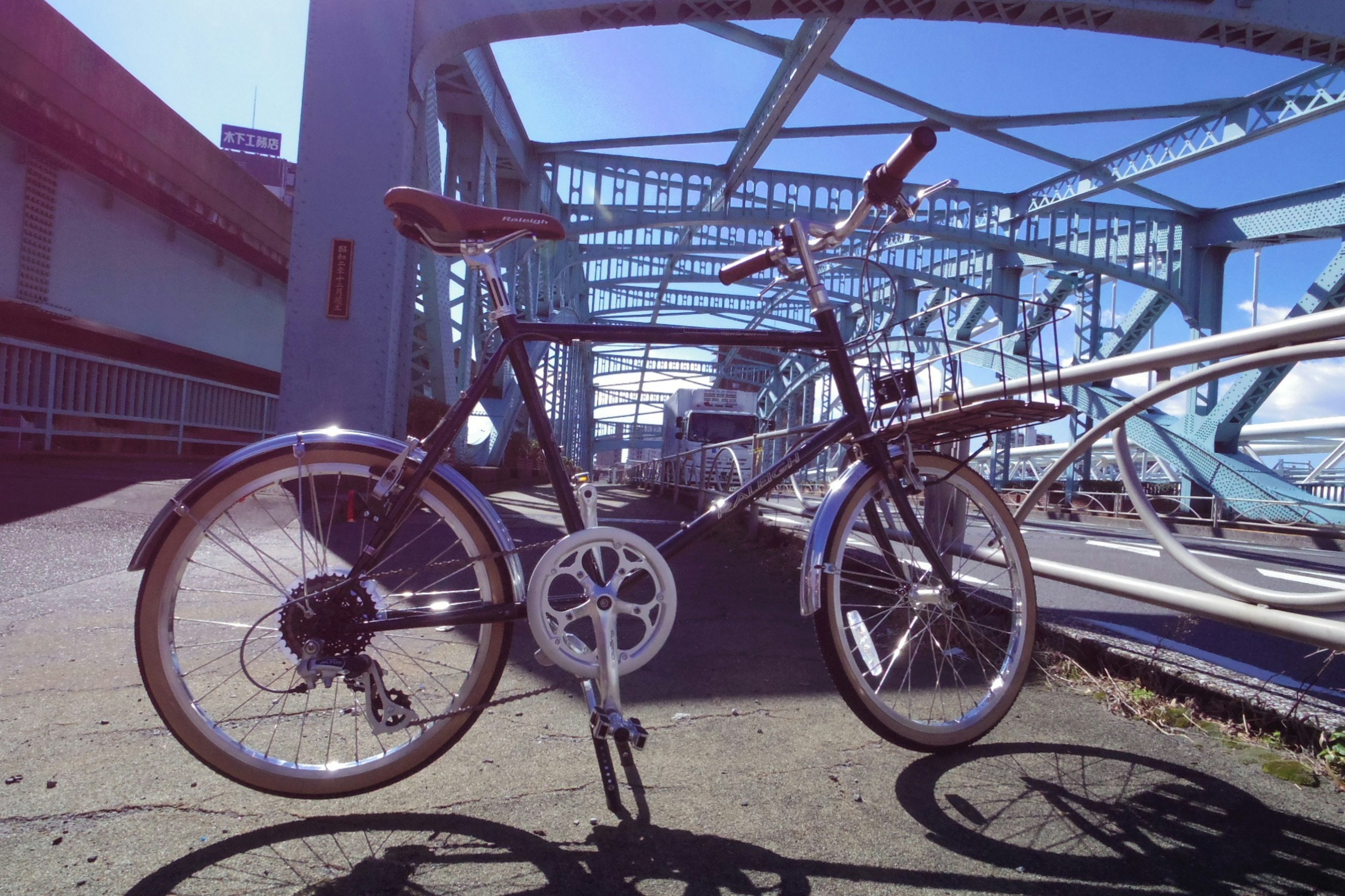 Bicicleta posicionada en un puente bajo un cielo azul claro