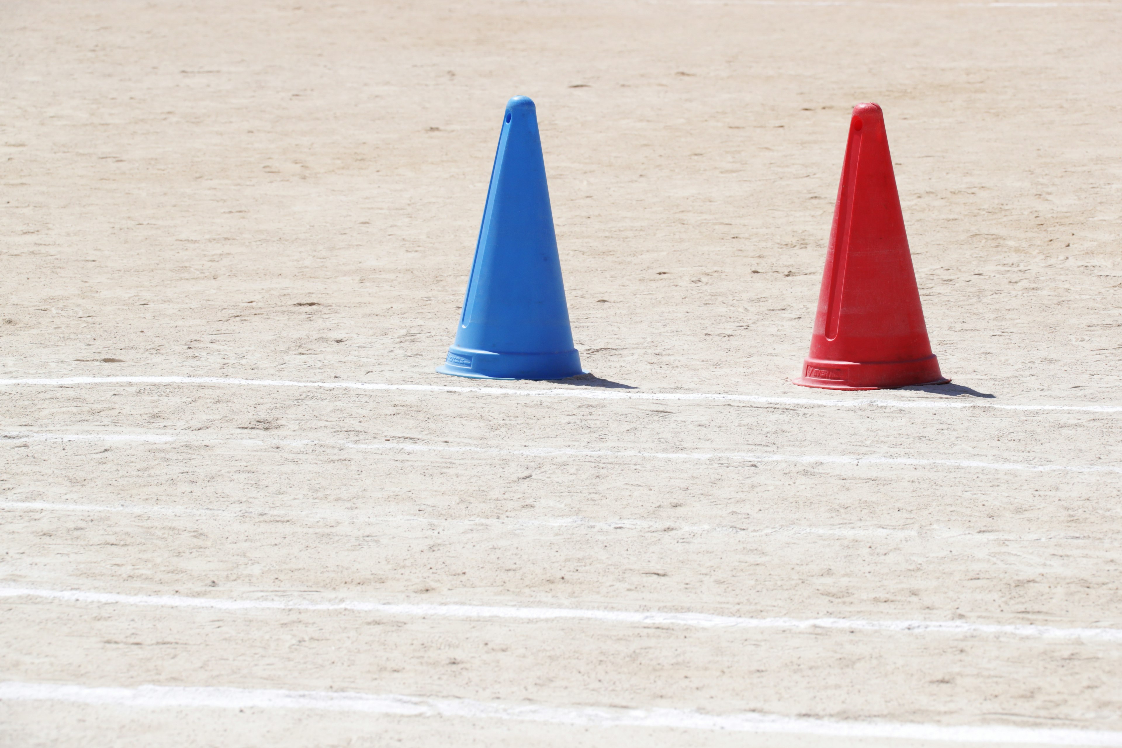 Blaue und rote Pylonen auf einem Sportfeld