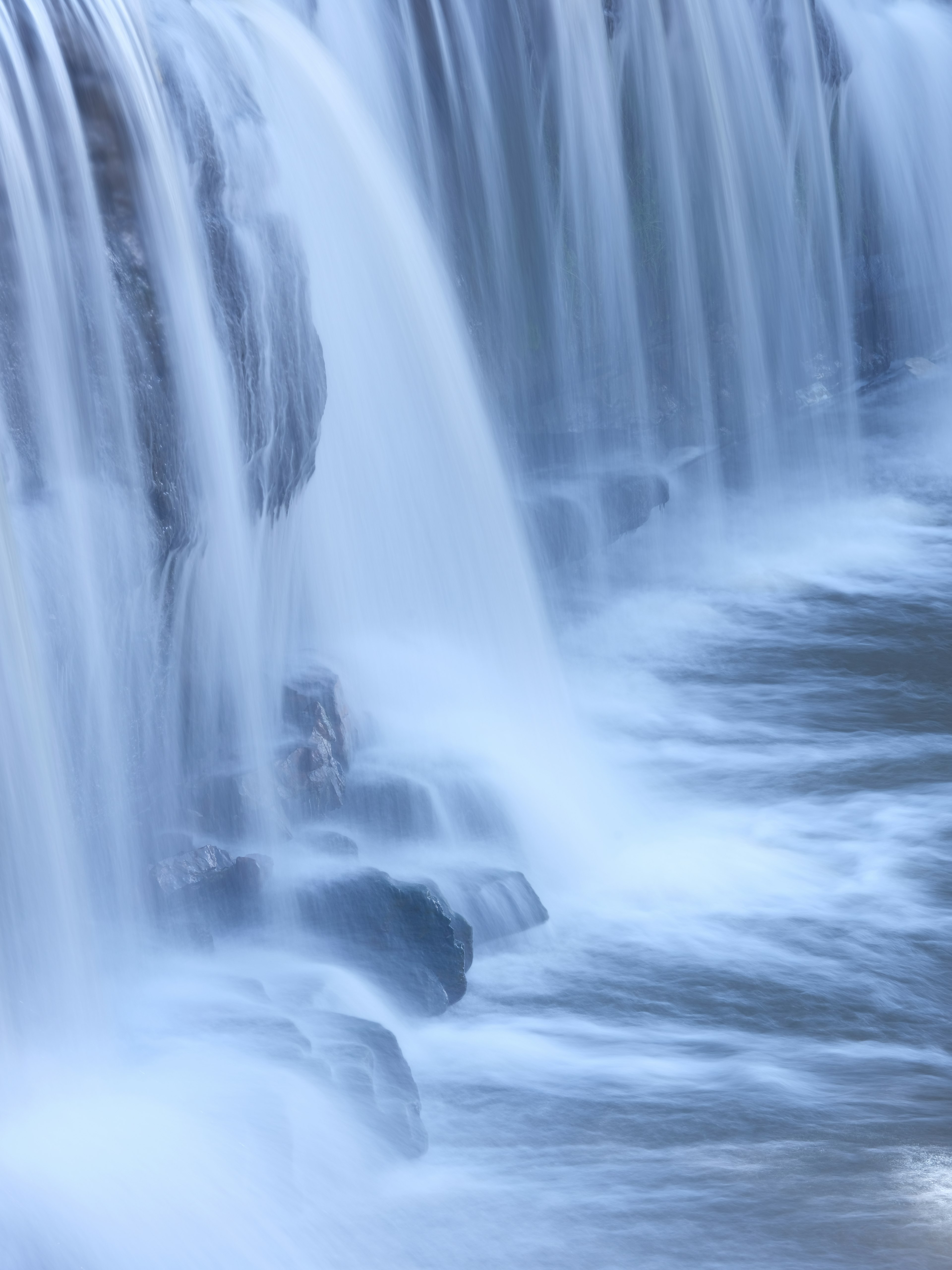 Nahaufnahme eines Wasserfalls, der über Felsen stürzt