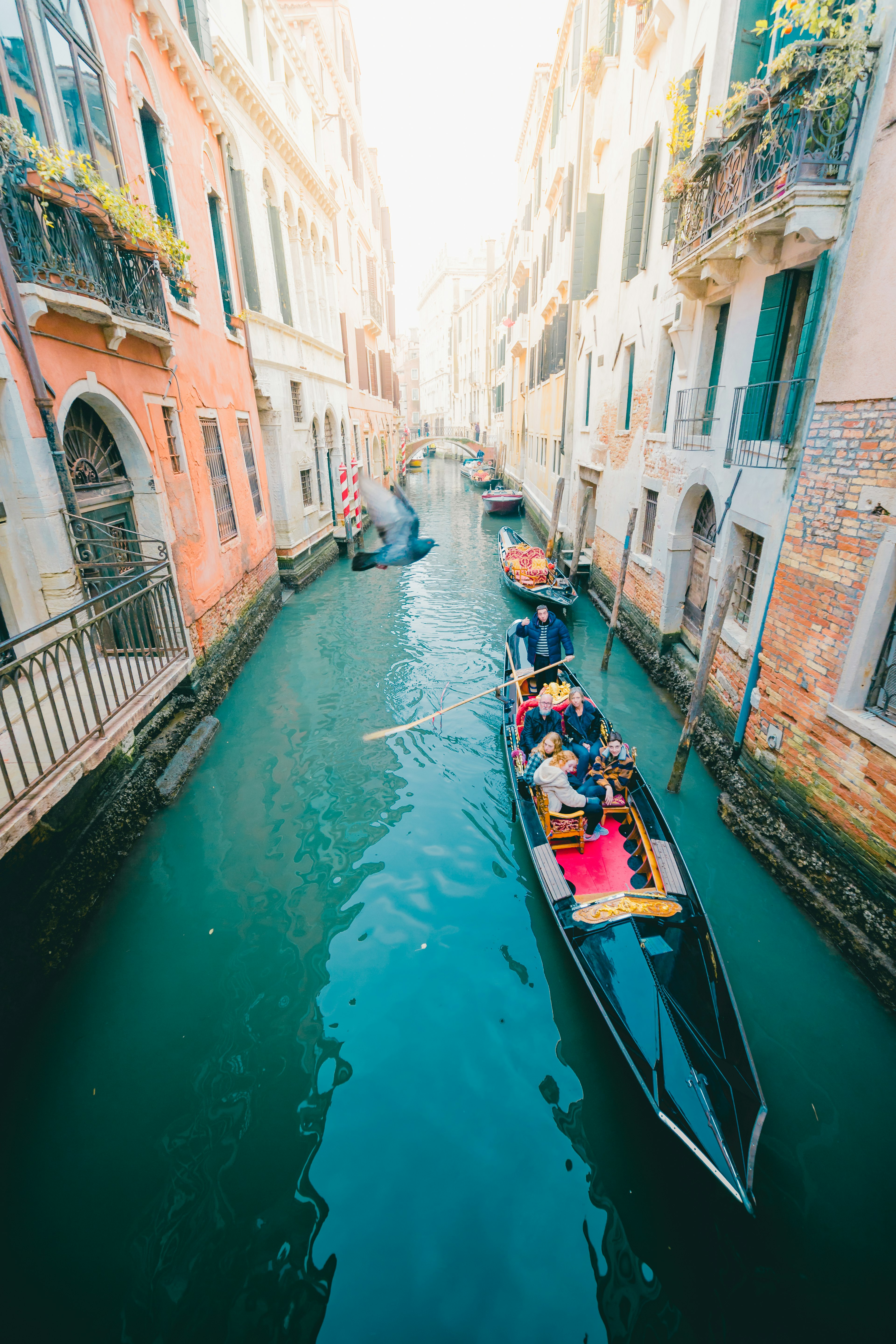 Una gondola che naviga in un canale stretto circondato da edifici colorati