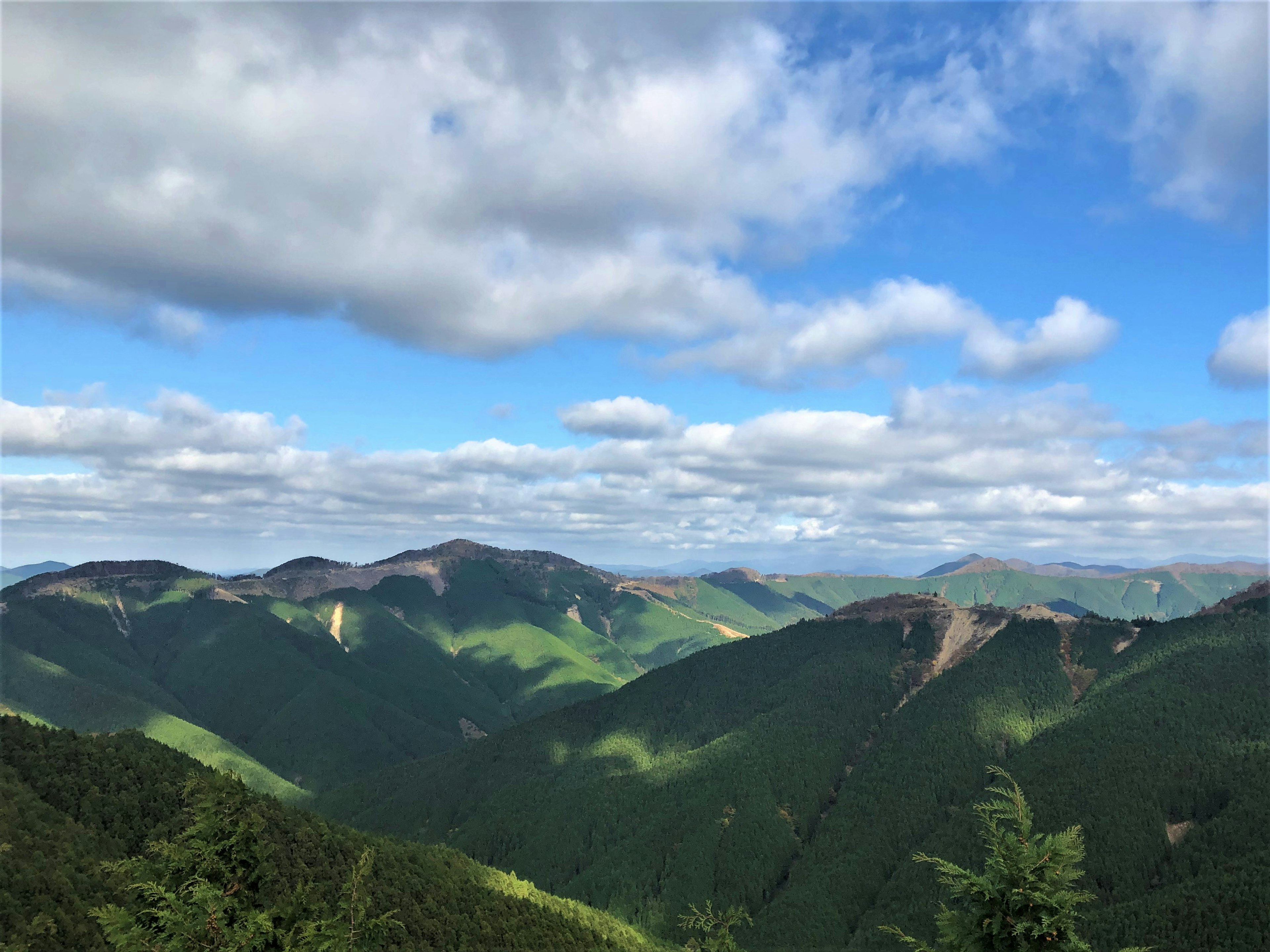 緑の山々と青い空に浮かぶ雲のパノラマ風景