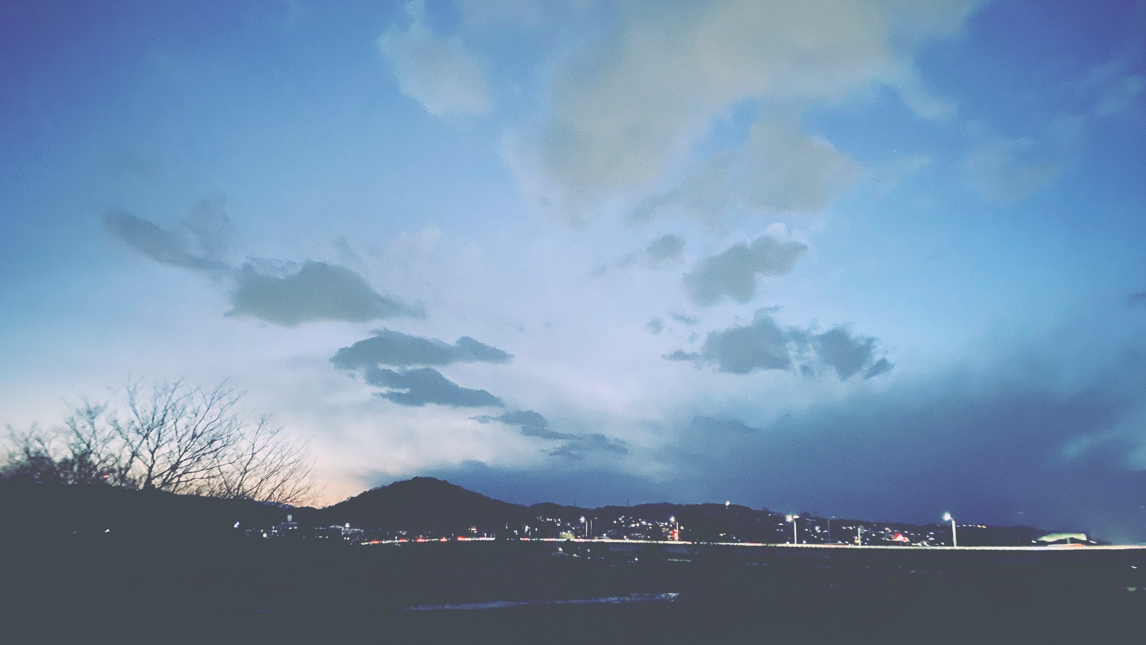 青い空と雲が広がる風景 自然の美しさ 山と街のシルエット