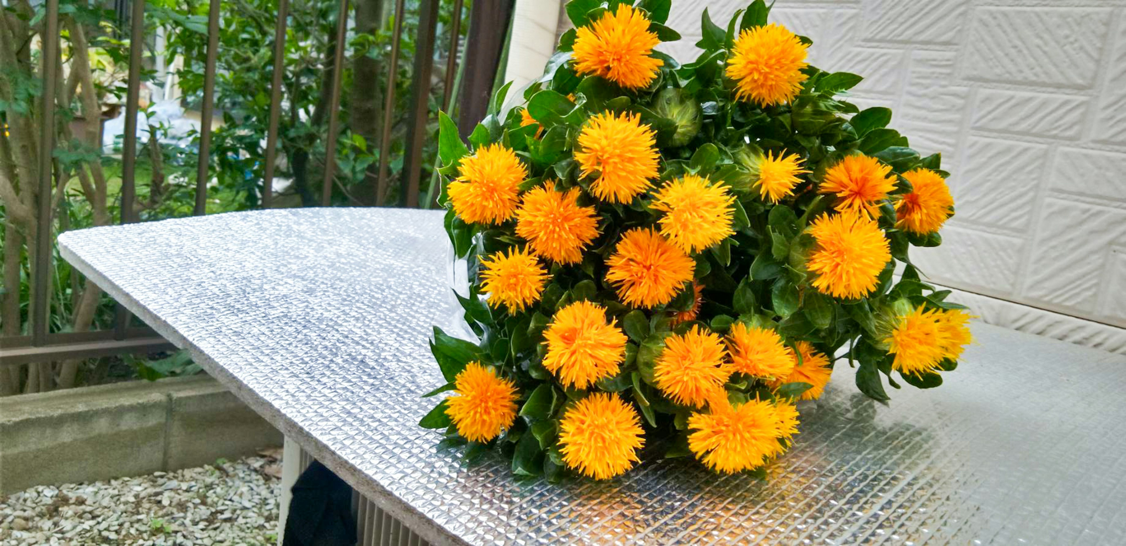 Un vibrante ramo de flores amarillas colocado sobre una mesa al aire libre