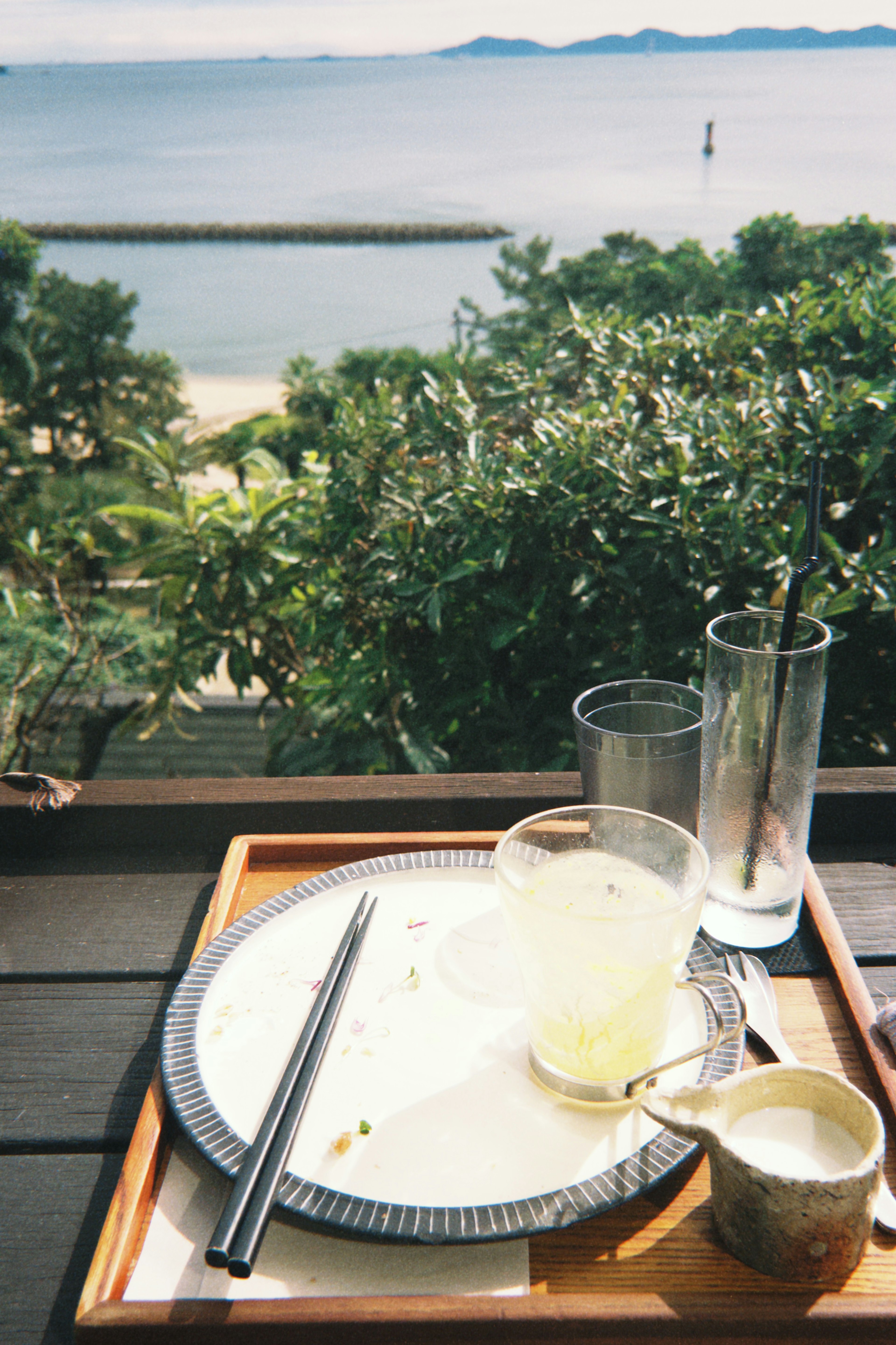 海の景色を背景にした食事のプレートと飲み物