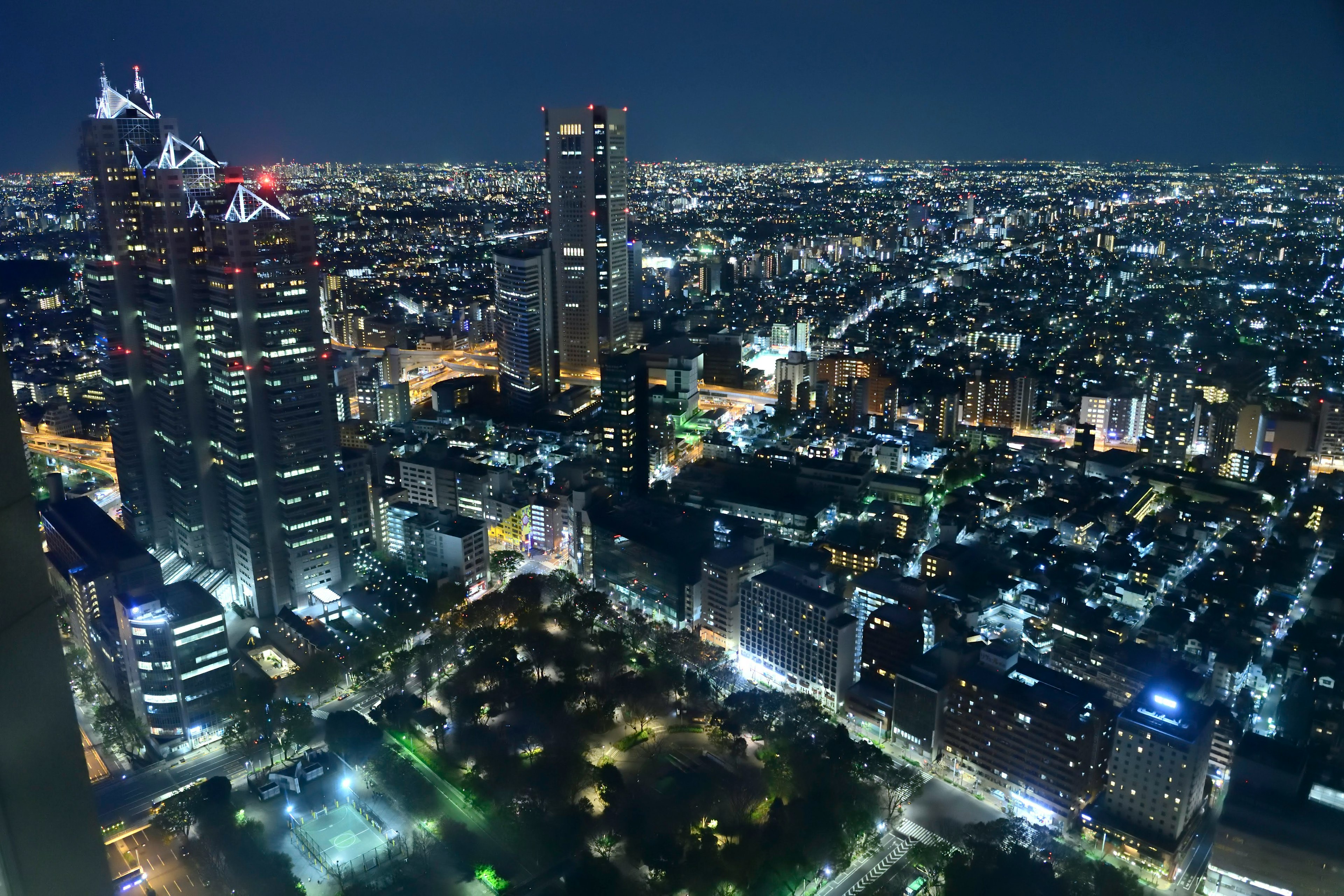 ทิวทัศน์ยามค่ำคืนของโตเกียว อาคารสูง ไฟถนนสว่าง สวนสีเขียว