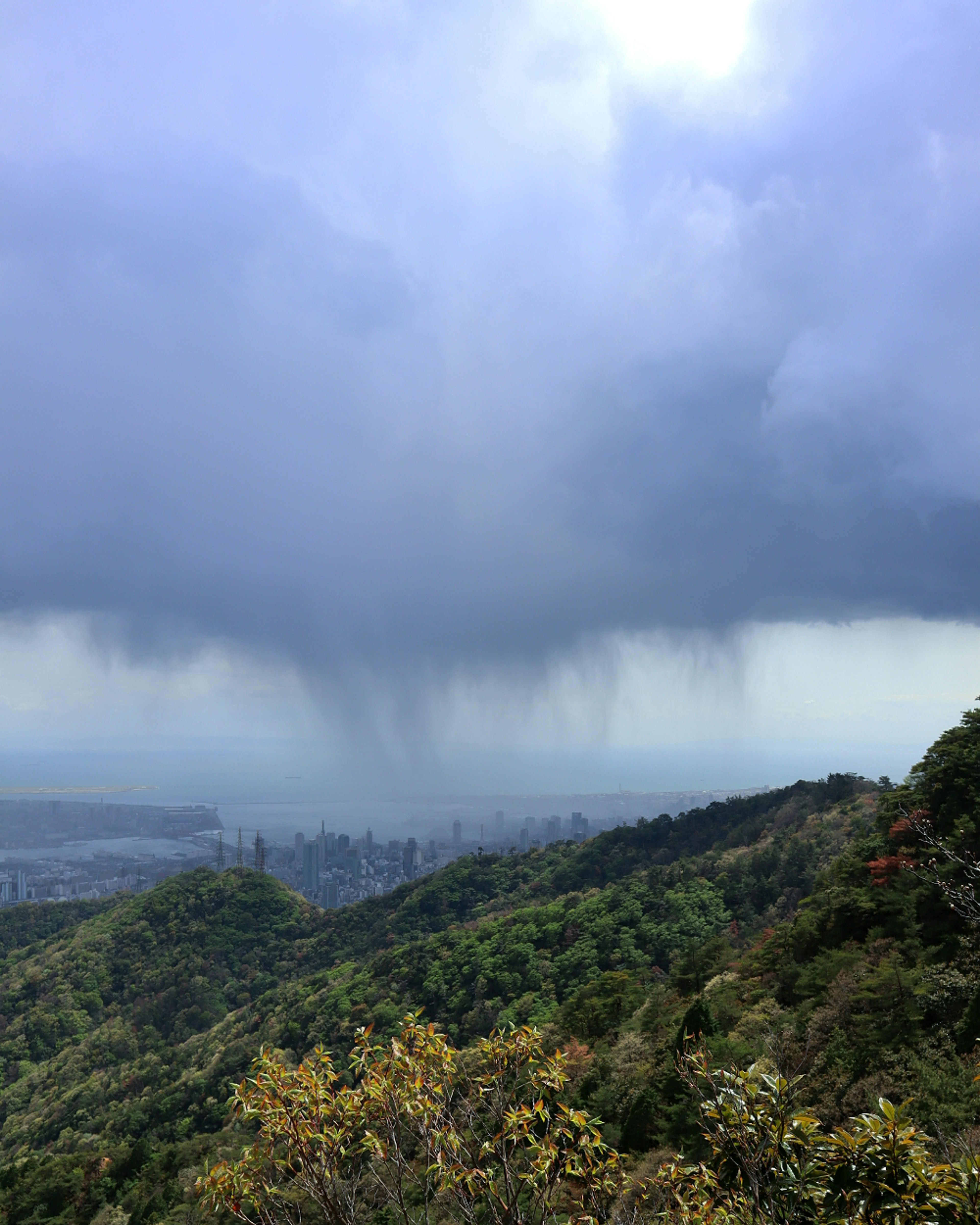 Una vista escénica de montañas verdes con nubes de lluvia amenazantes