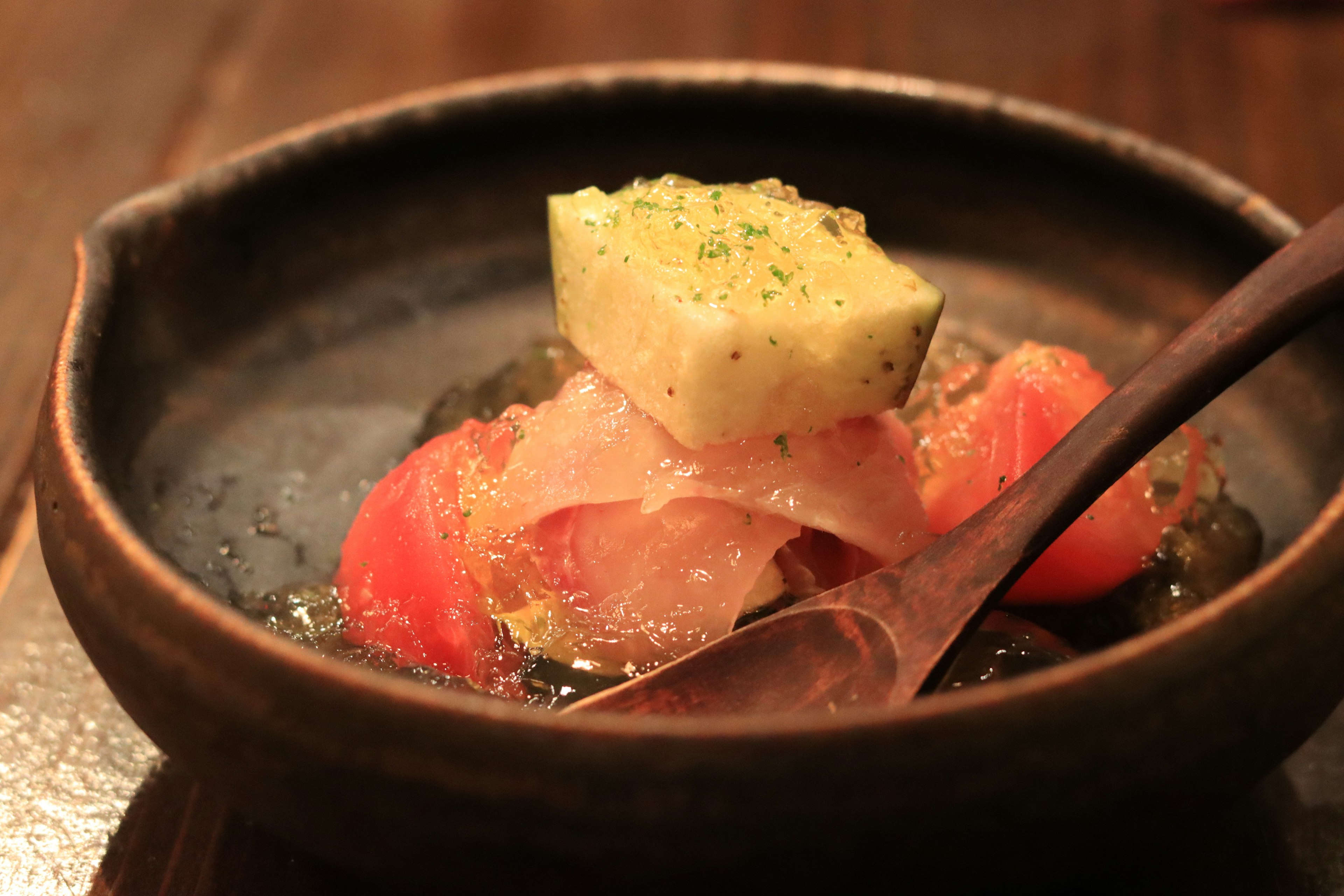 Un pequeño tazón de cocina japonesa con pescado fresco y verduras