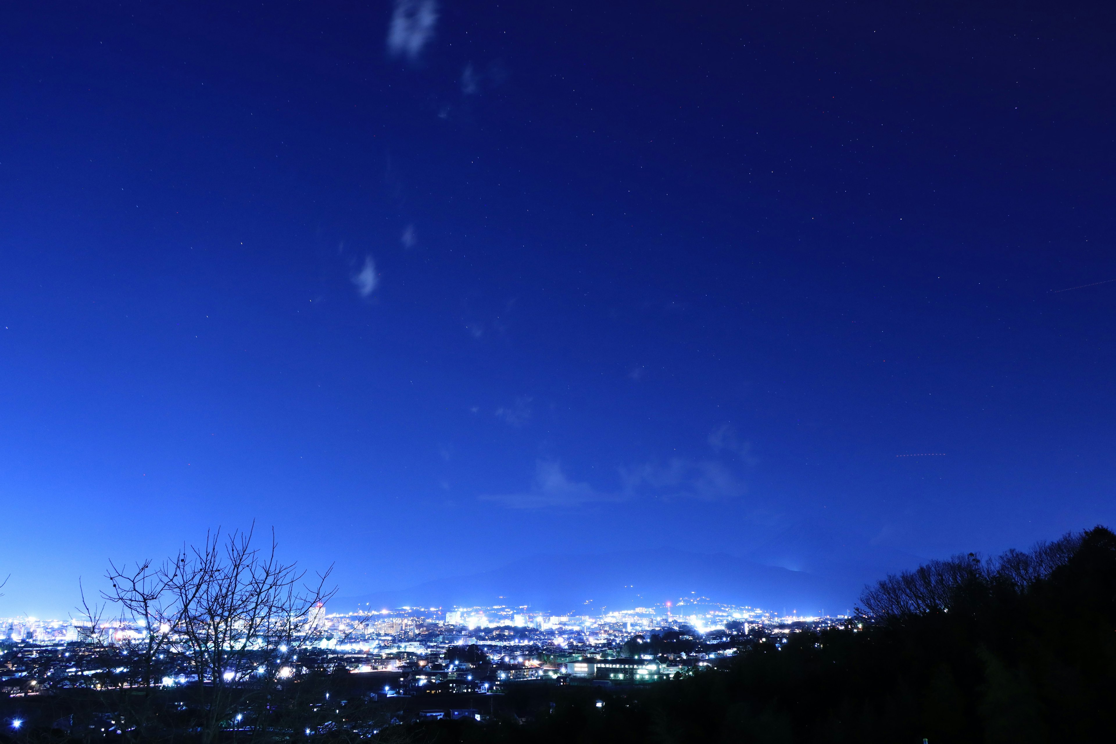 Cielo notturno con tonalità di blu intenso e luci della città scintillanti