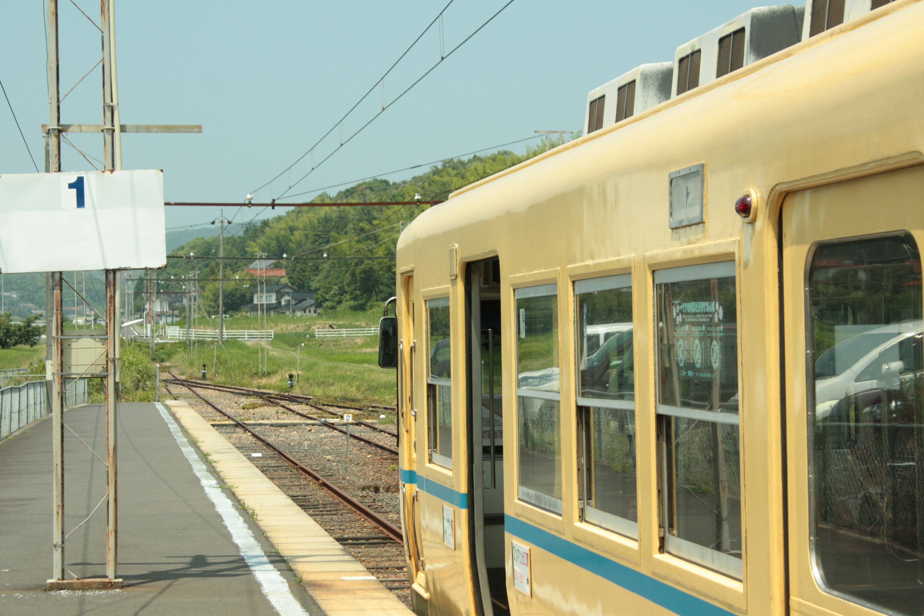 黄色い電車が停車している駅の風景