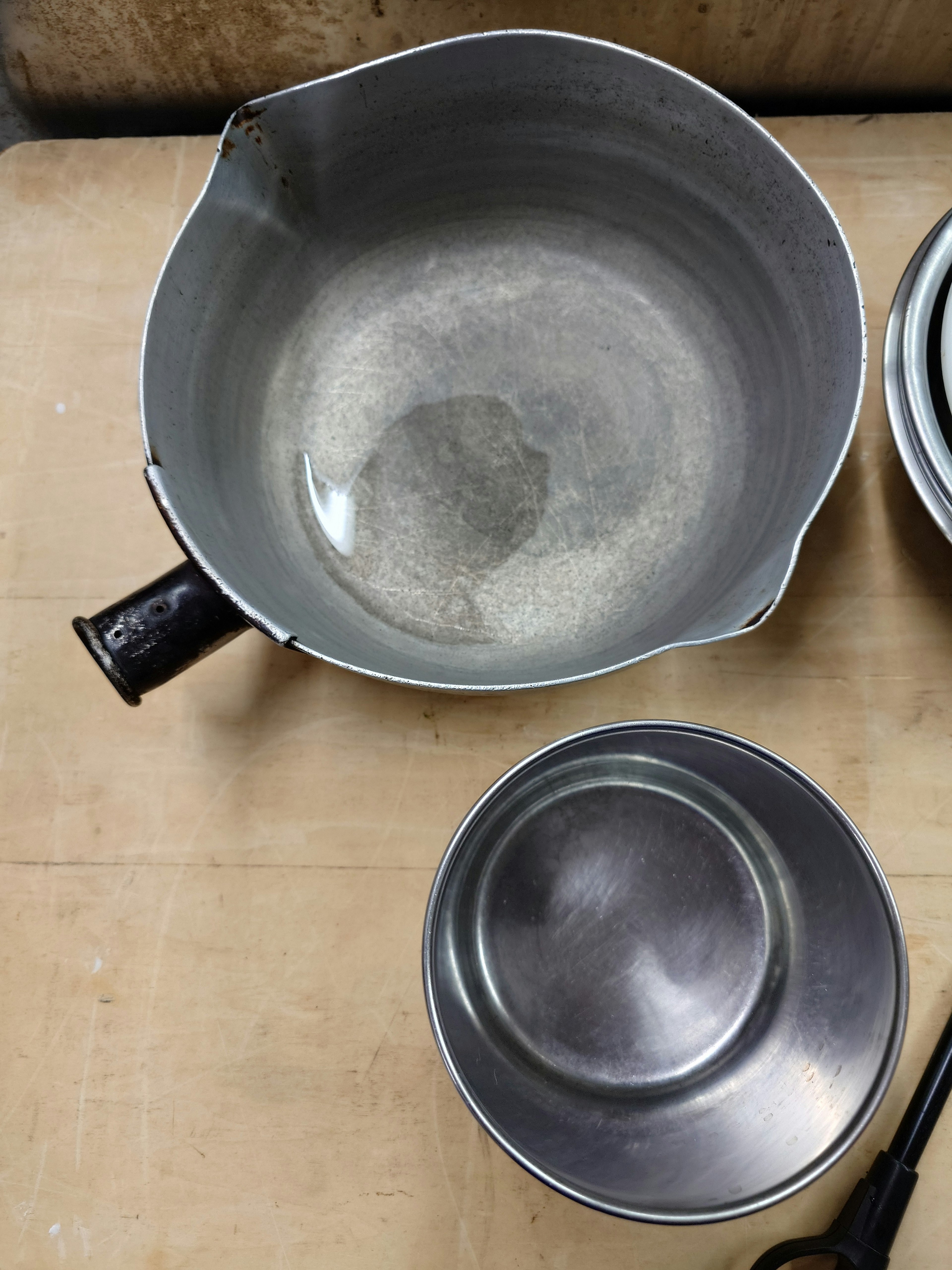 Tazón de metal y plato pequeño colocados sobre una mesa