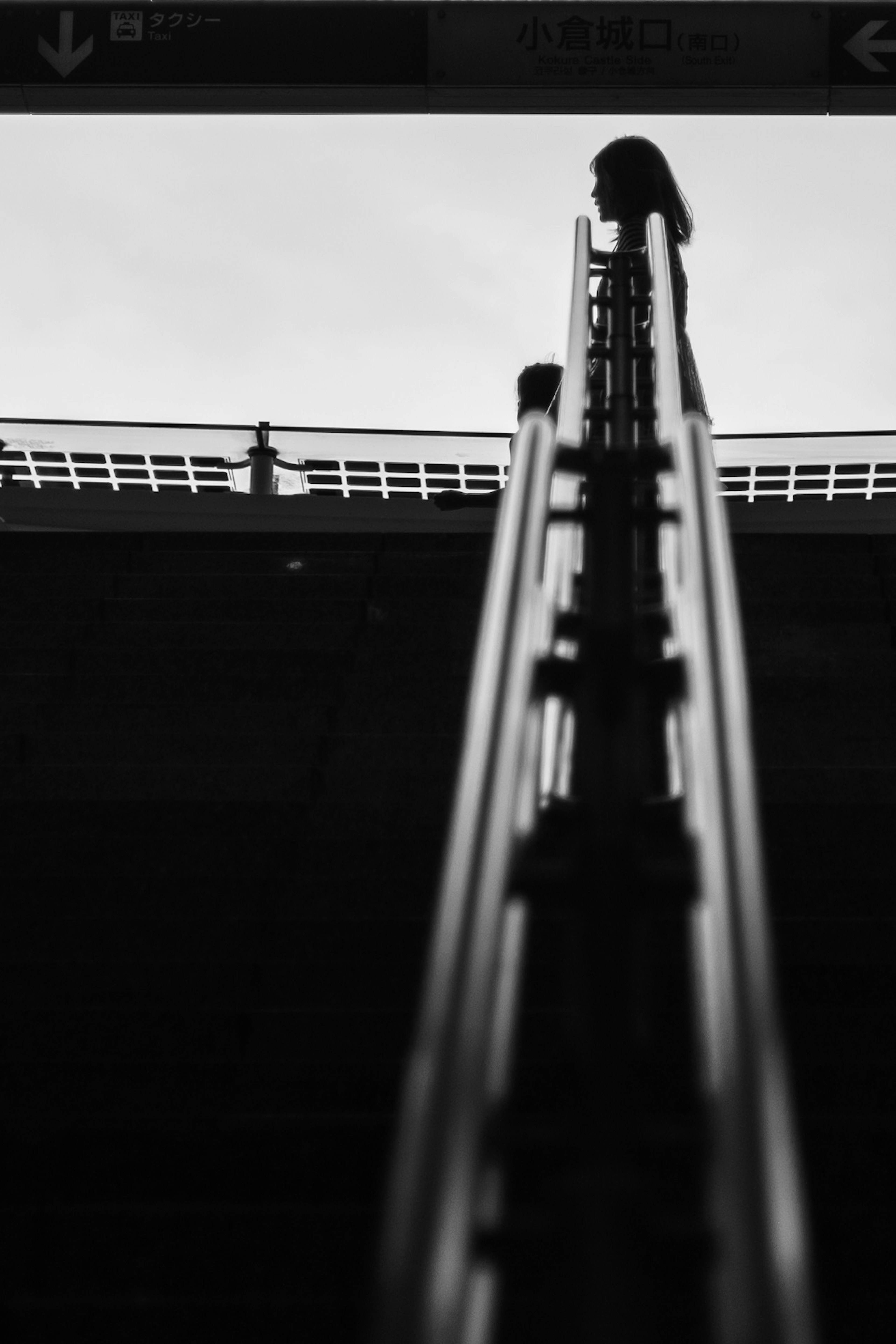 Silhouette d'une personne montant des escaliers en noir et blanc