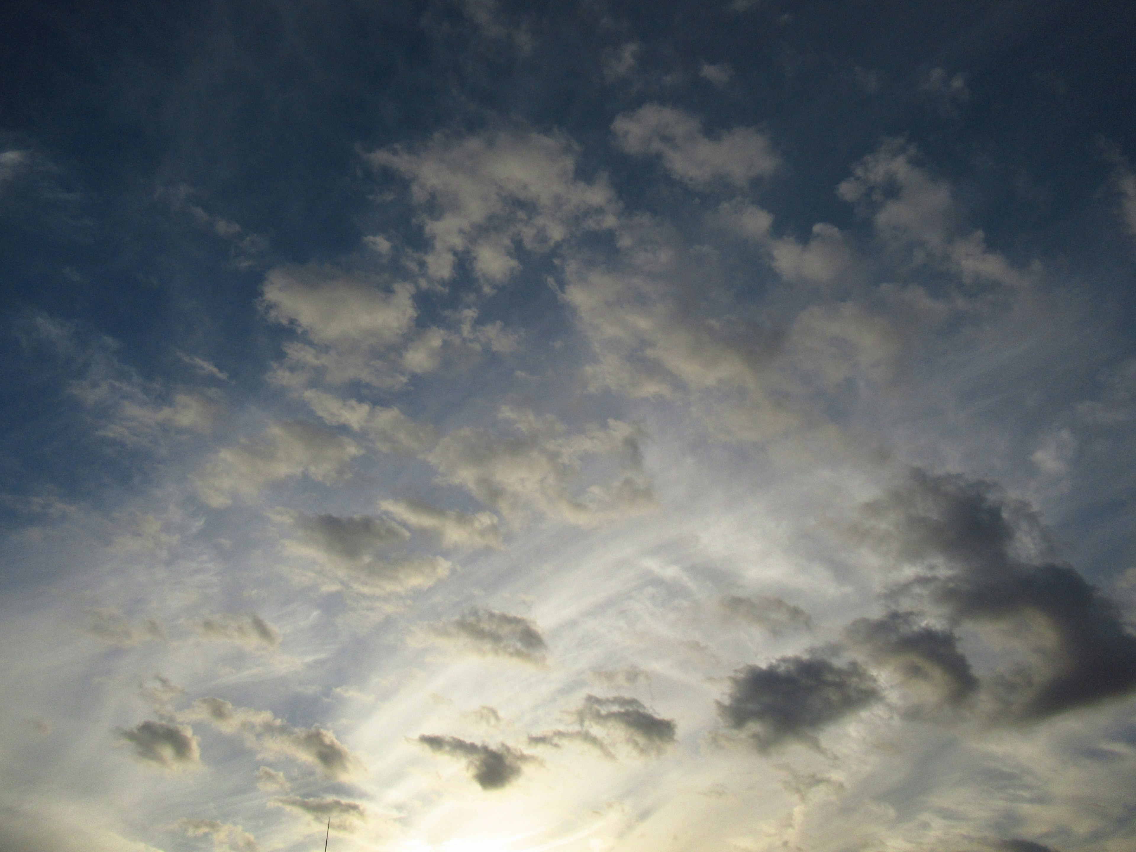 青空に浮かぶ雲のパターンと柔らかな光