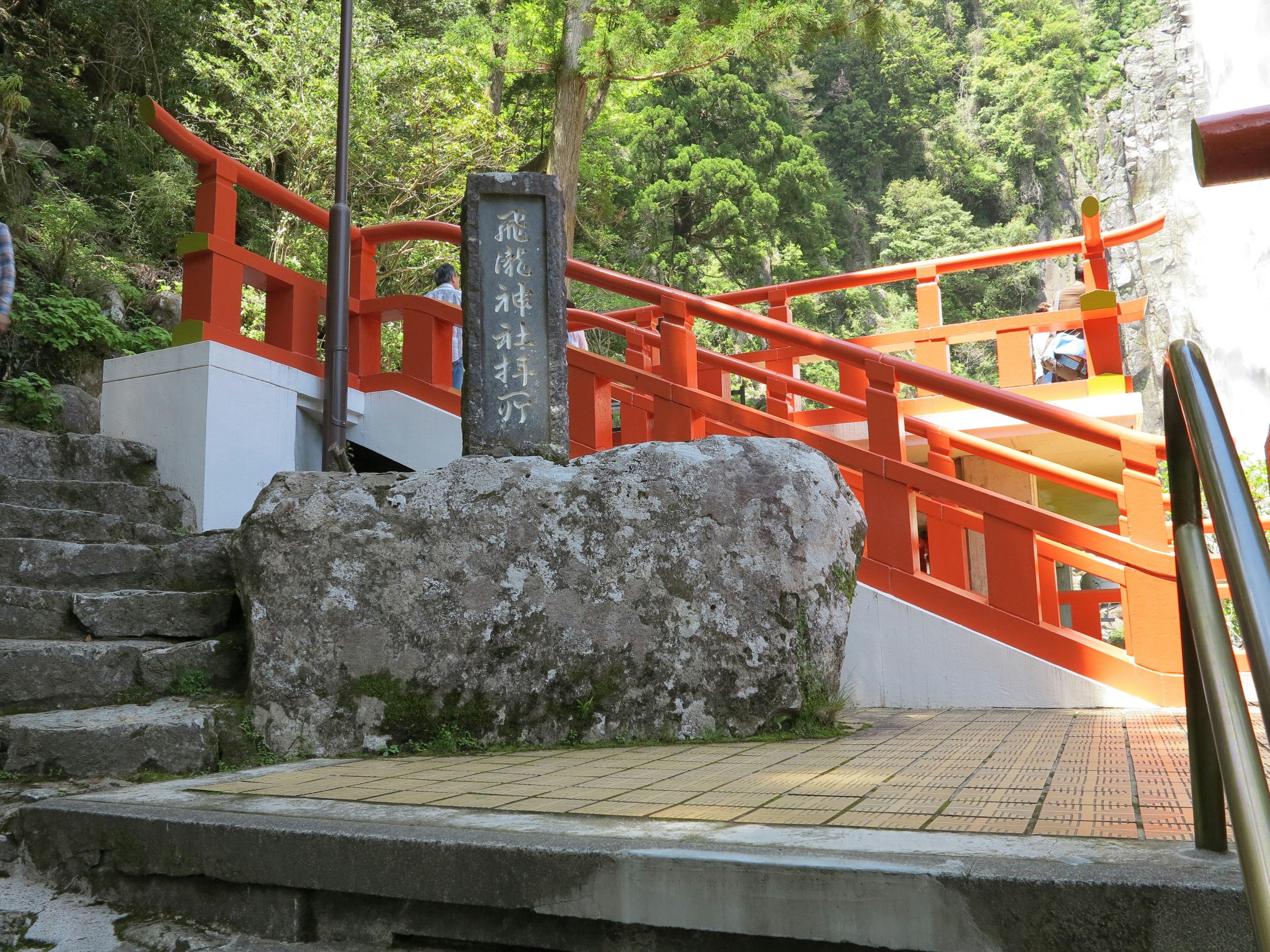 赤い橋と石の標識がある自然の景観