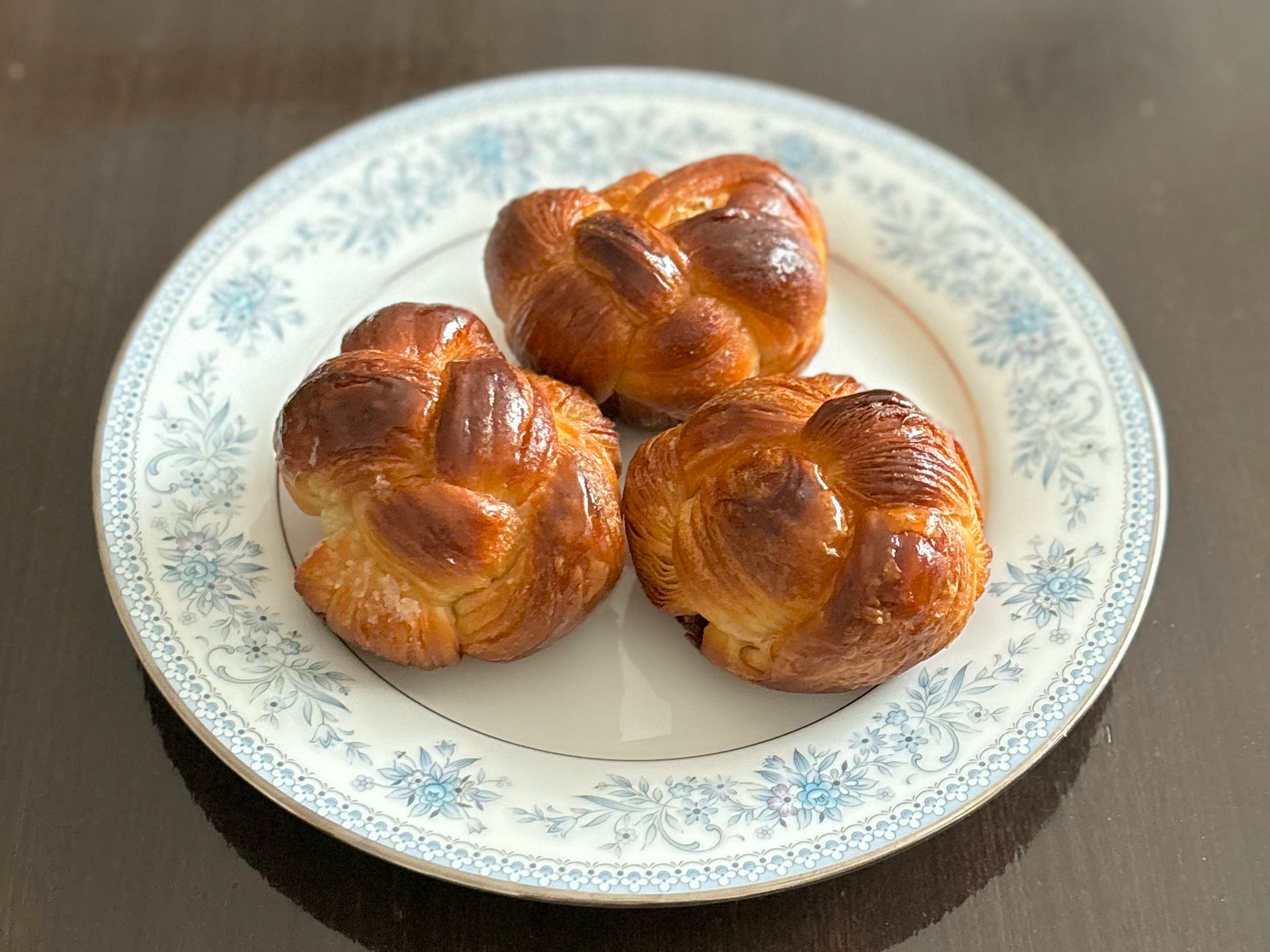 Three freshly baked pastries arranged on a decorative plate