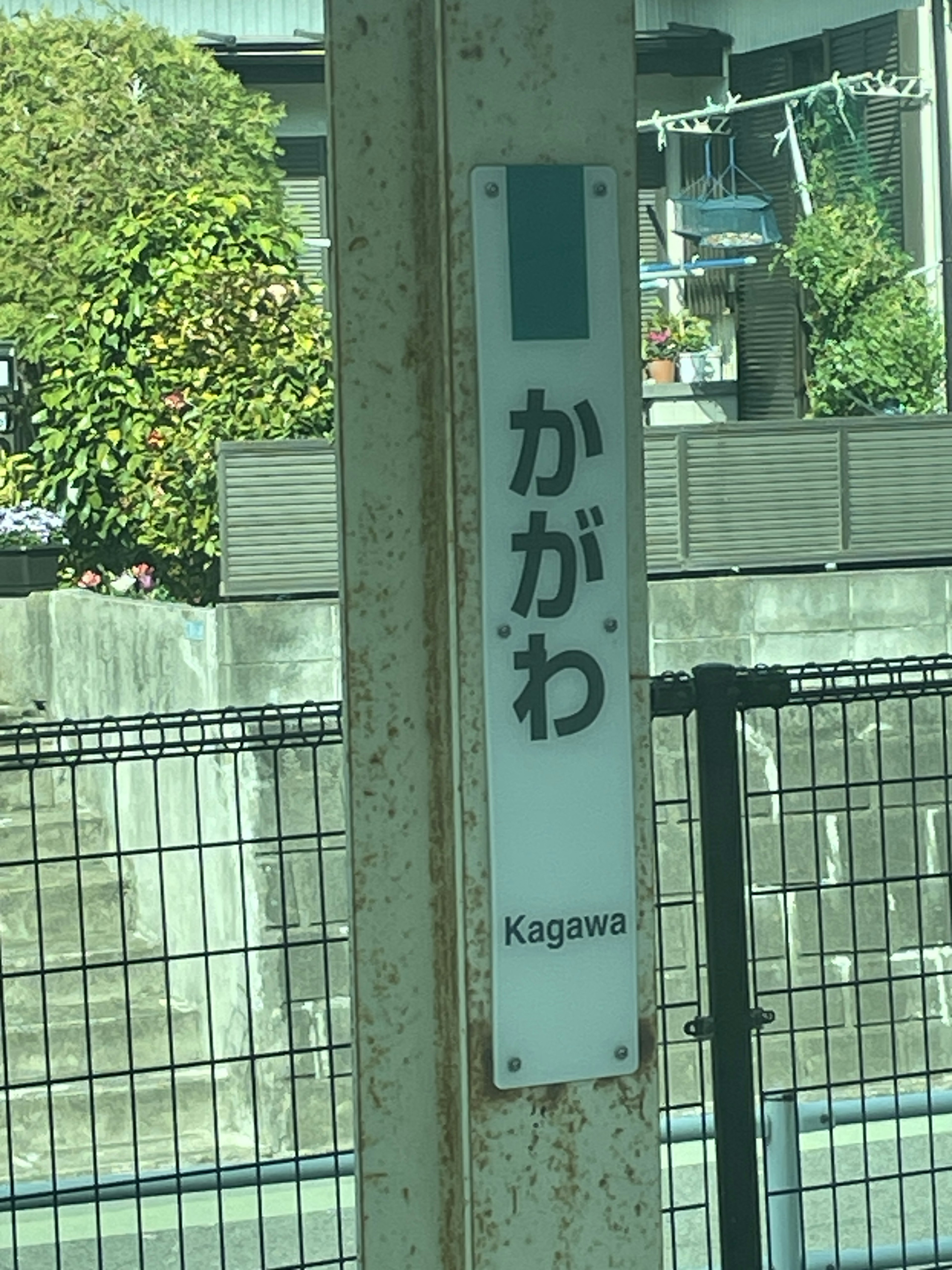 Schild der Station Kagawa mit umliegendem Grün