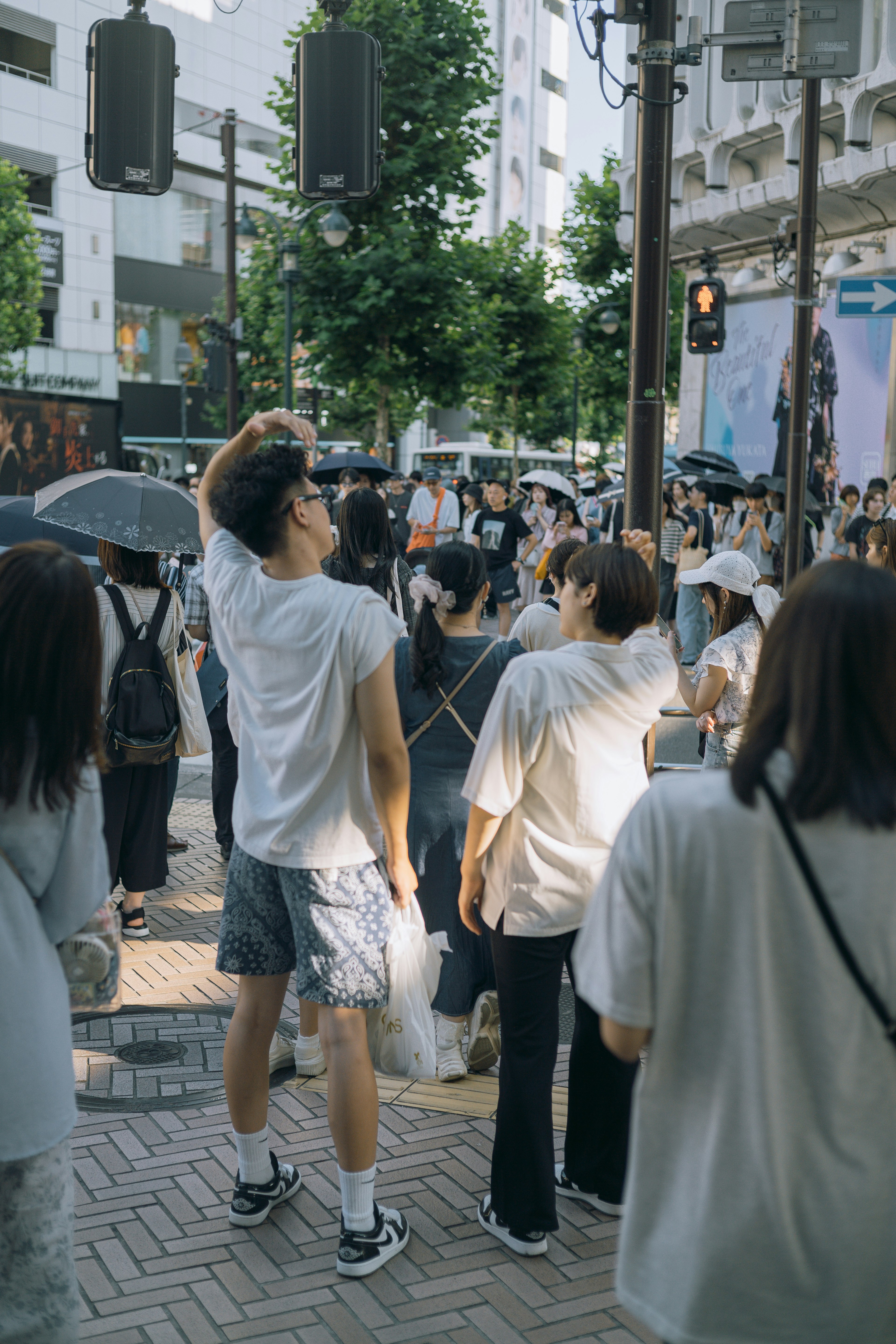 People in white clothing gathering at a crosswalk