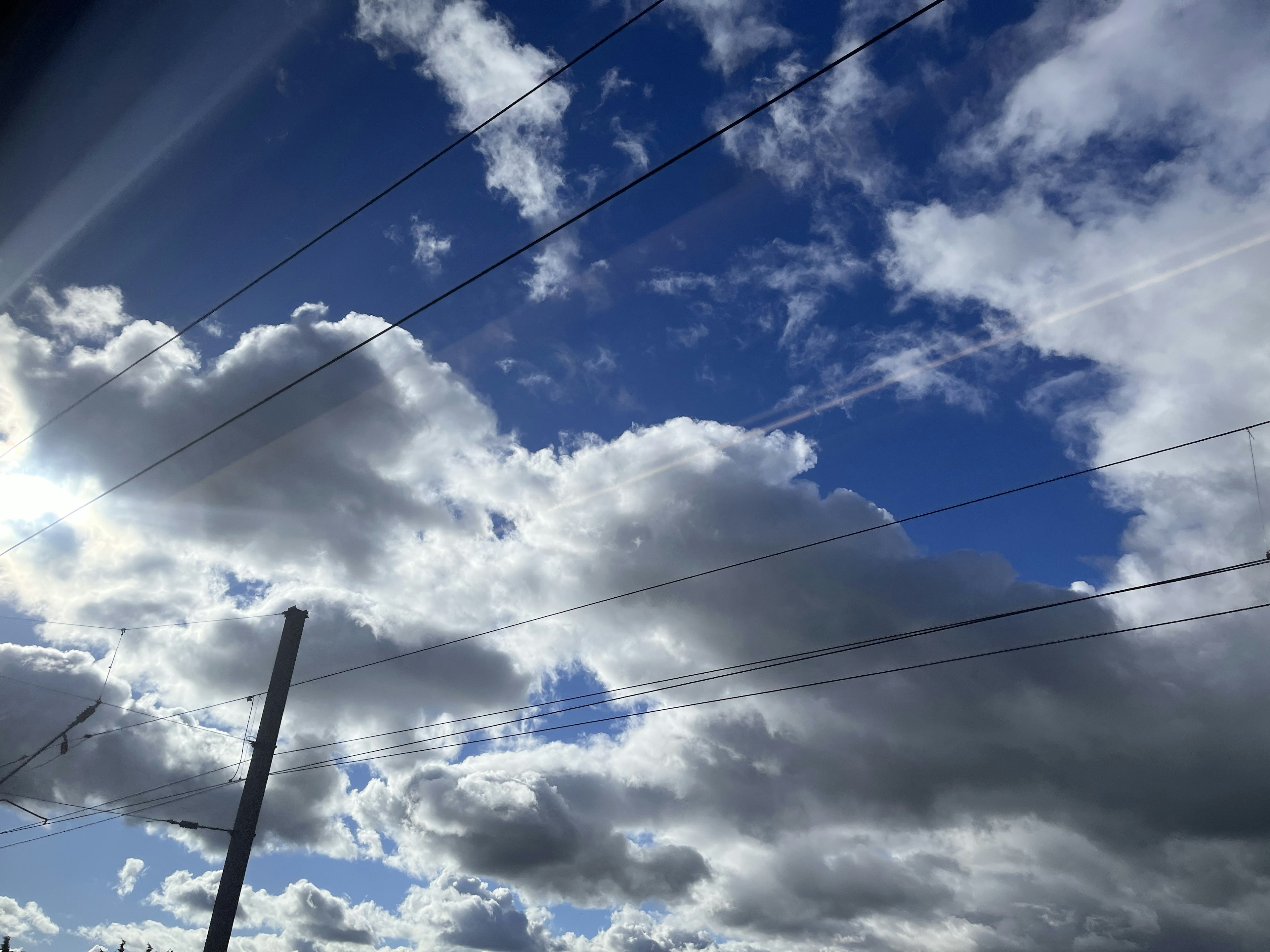 青空に白い雲と電線が見える風景