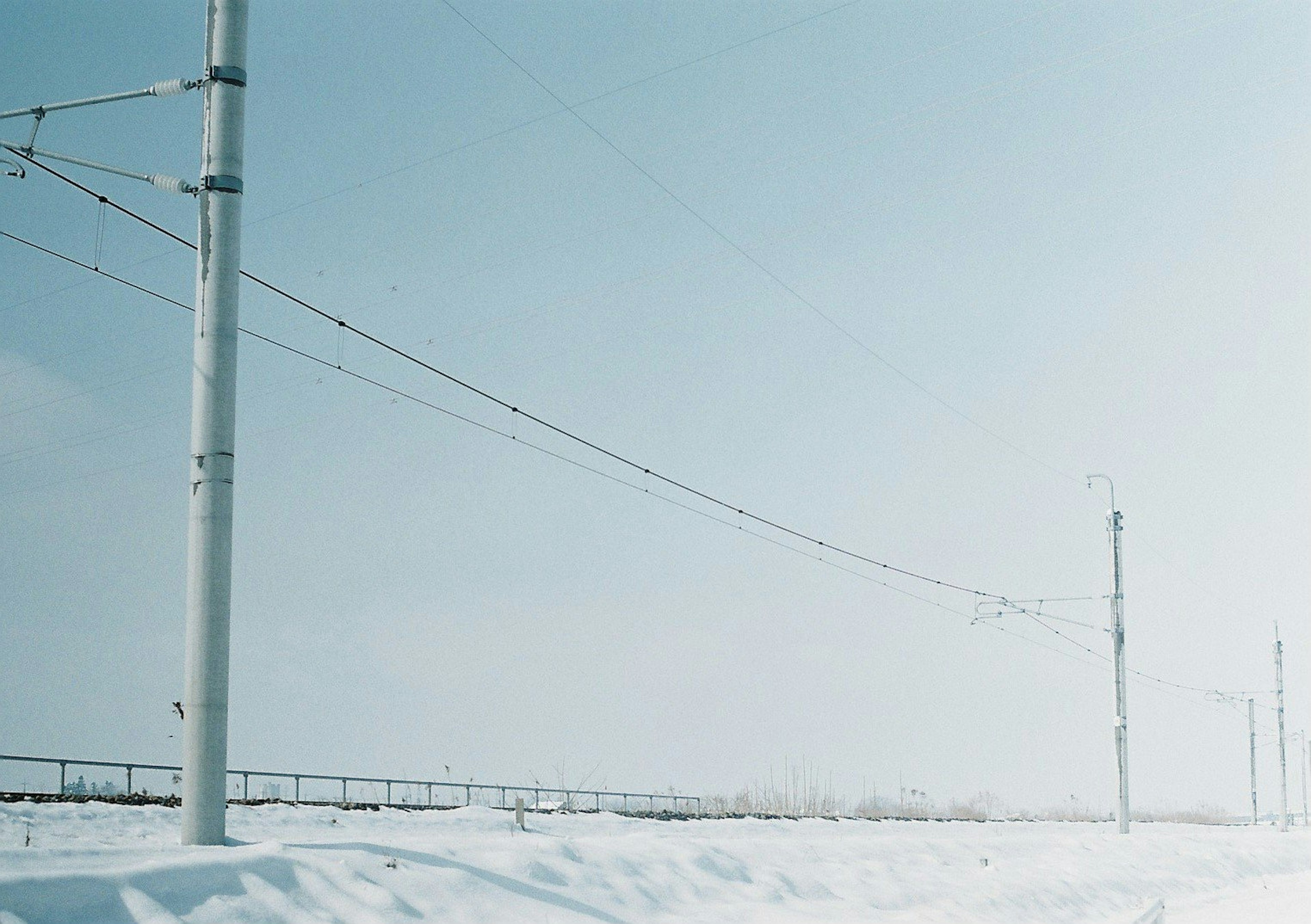 Power poles and wires in a snowy landscape