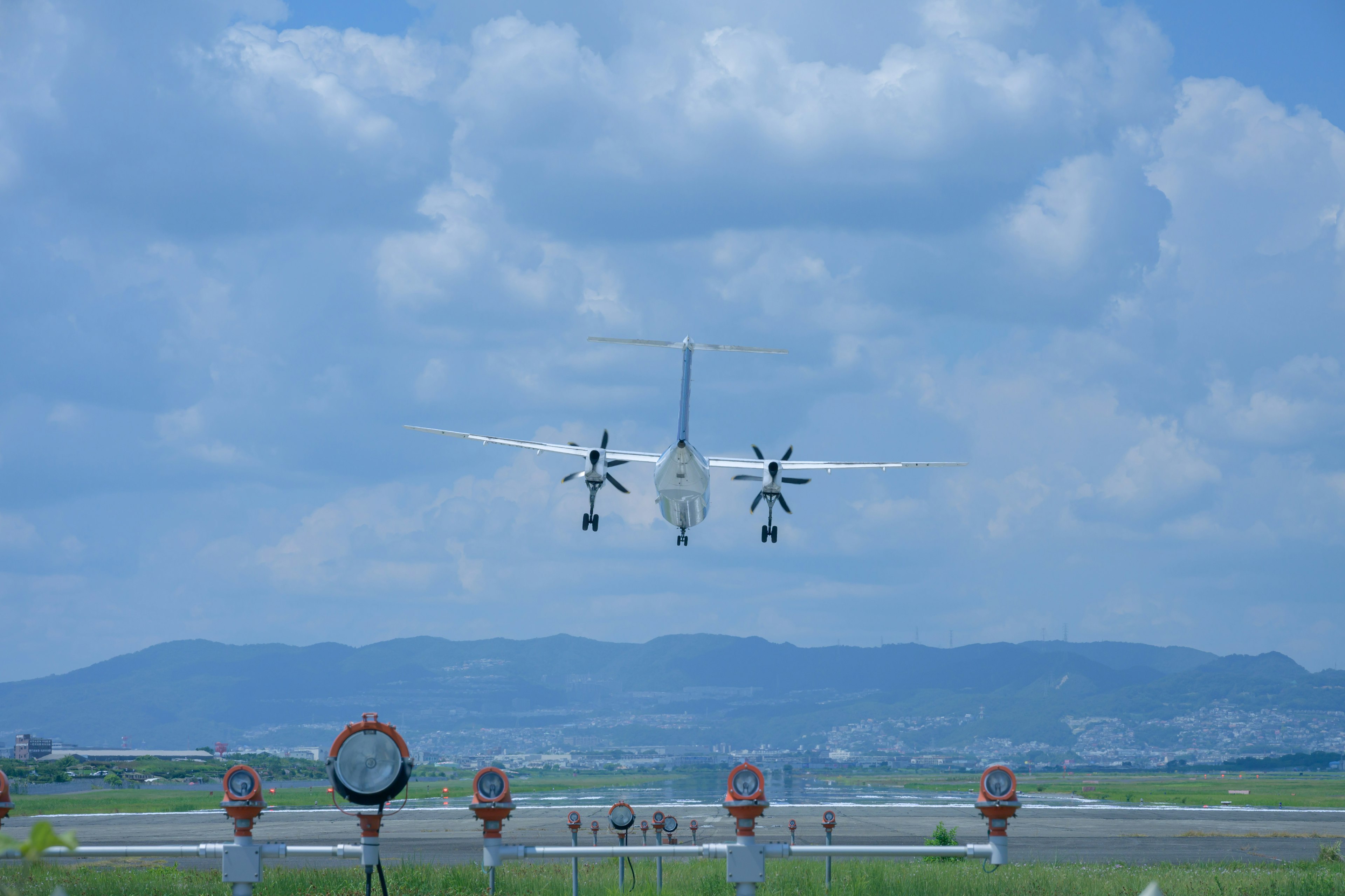 Pesawat propeller mendarat di bandara di bawah langit biru