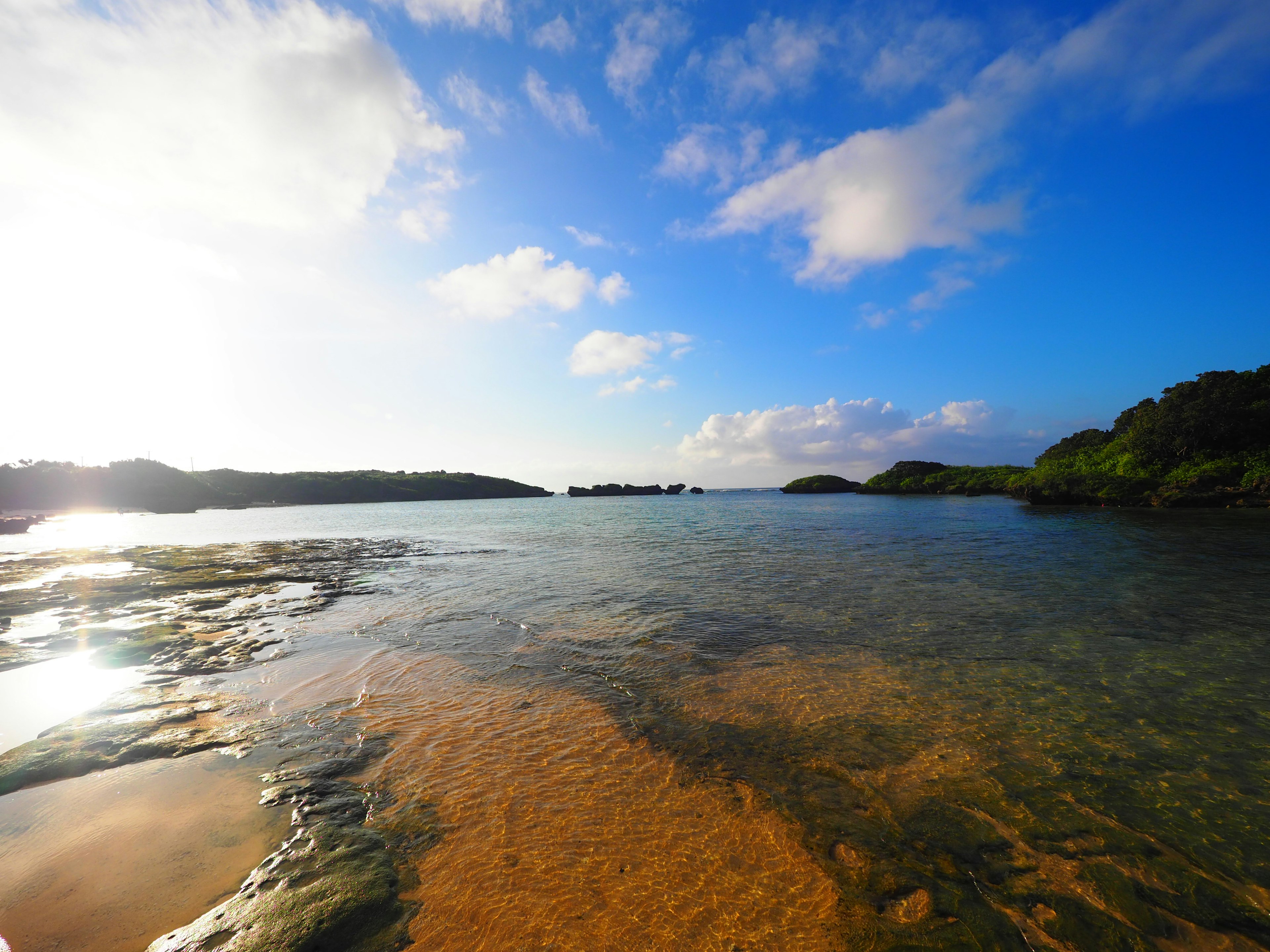 Paysage maritime magnifique avec ciel bleu et nuages blancs surface de l'eau calme et rivage de sable