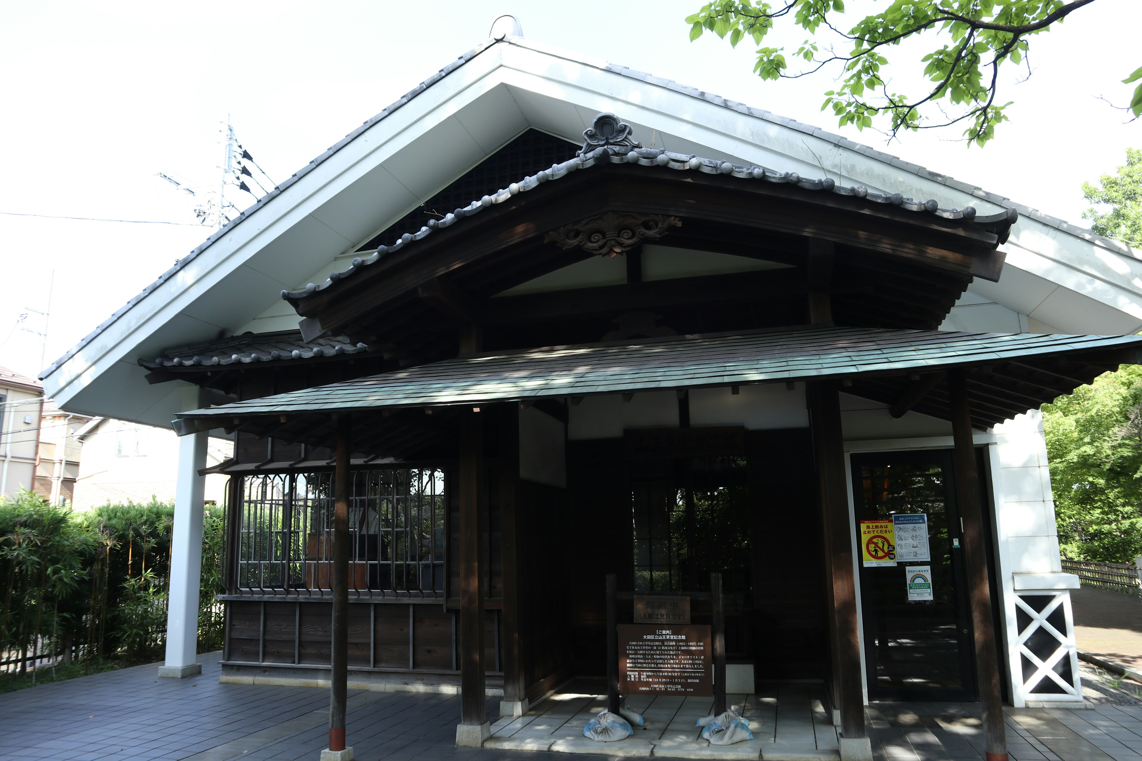 Traditional Japanese house featuring a contrasting white and black exterior large roof and wooden pillars