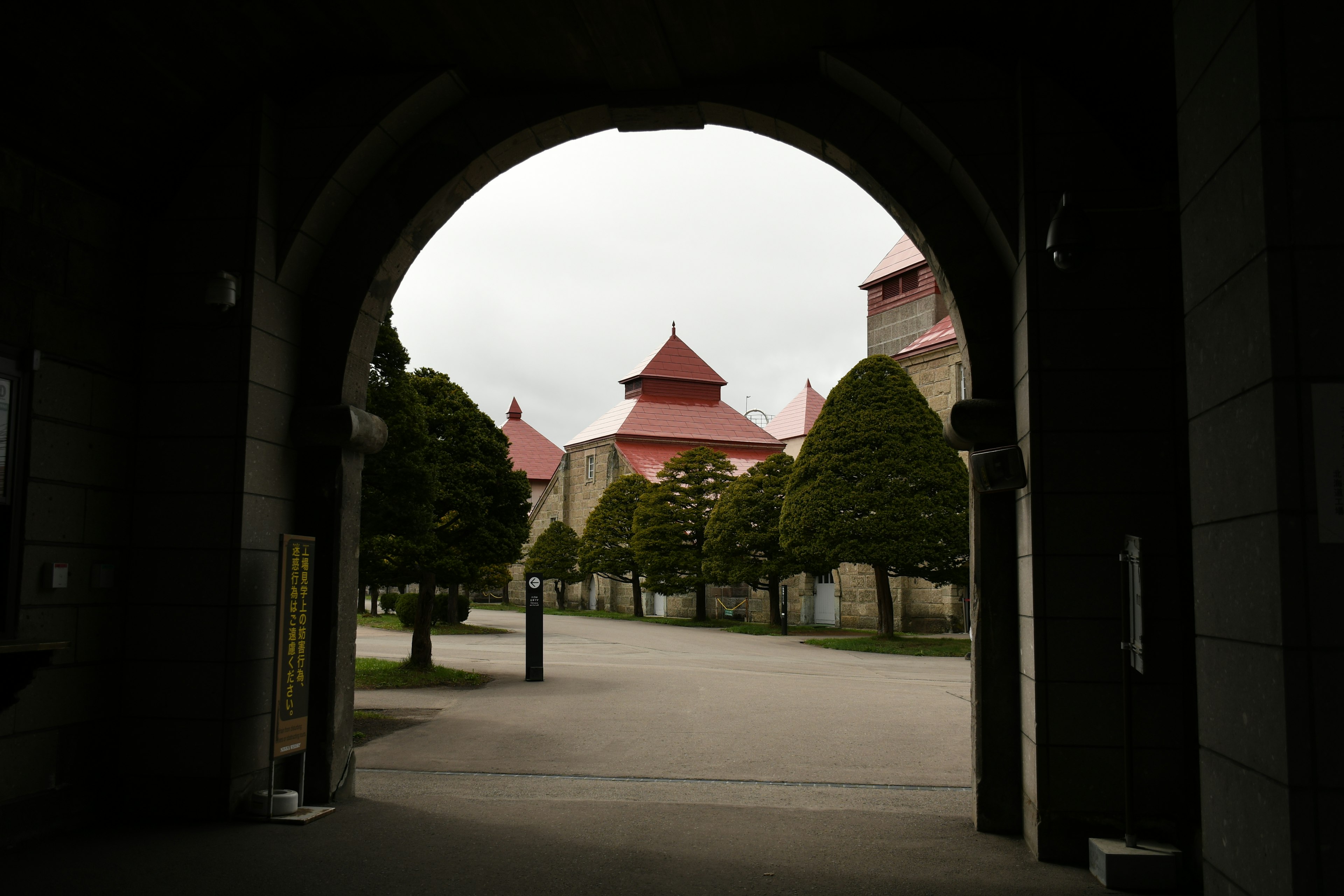 Archway view of historical buildings with green trees