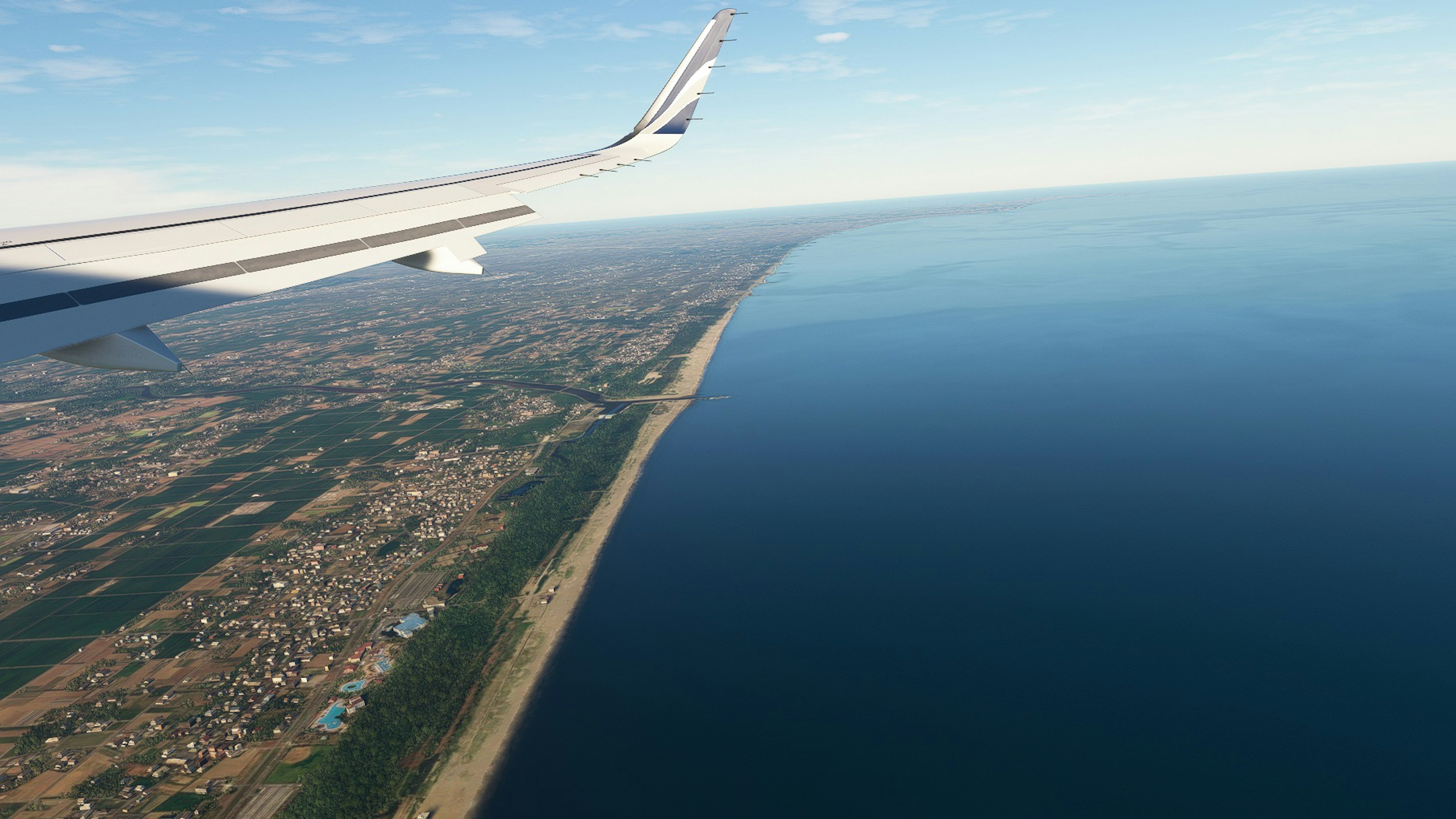 Aerial view of an airplane wing over a coastline and ocean