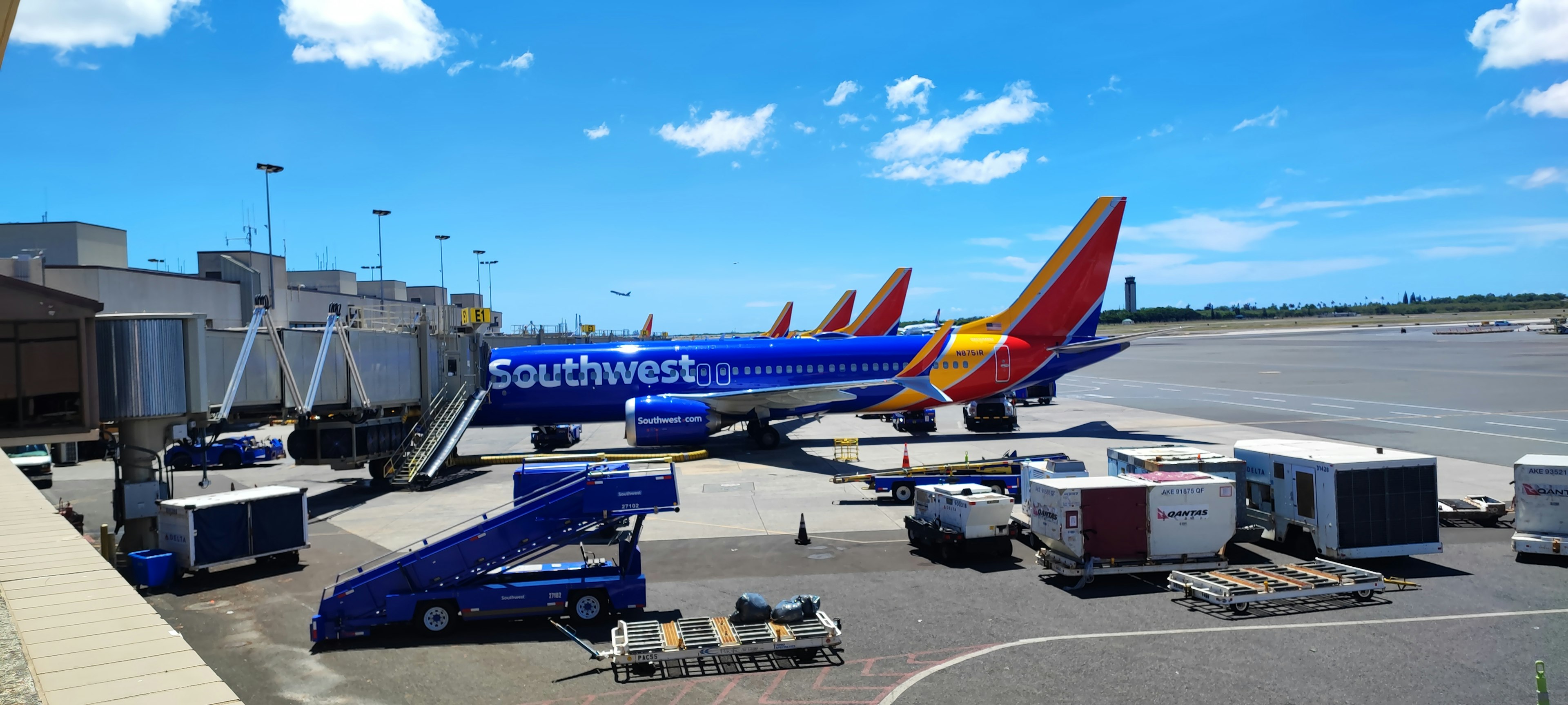 Southwest Airlines planes parked at an airport gate under a clear blue sky