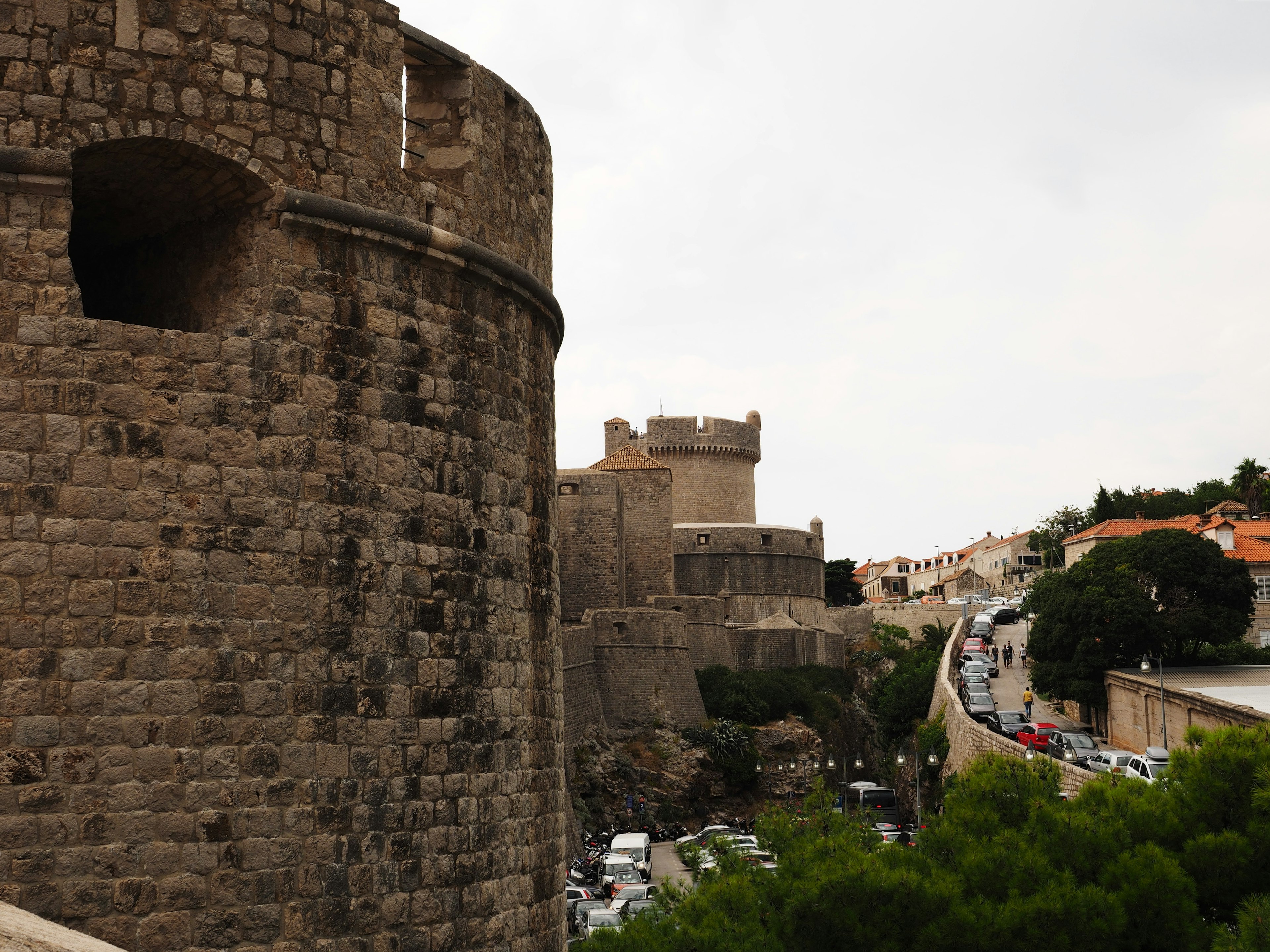 Muri di castello in pietra e torri visibili nel paesaggio Esterno del castello e strada circostante